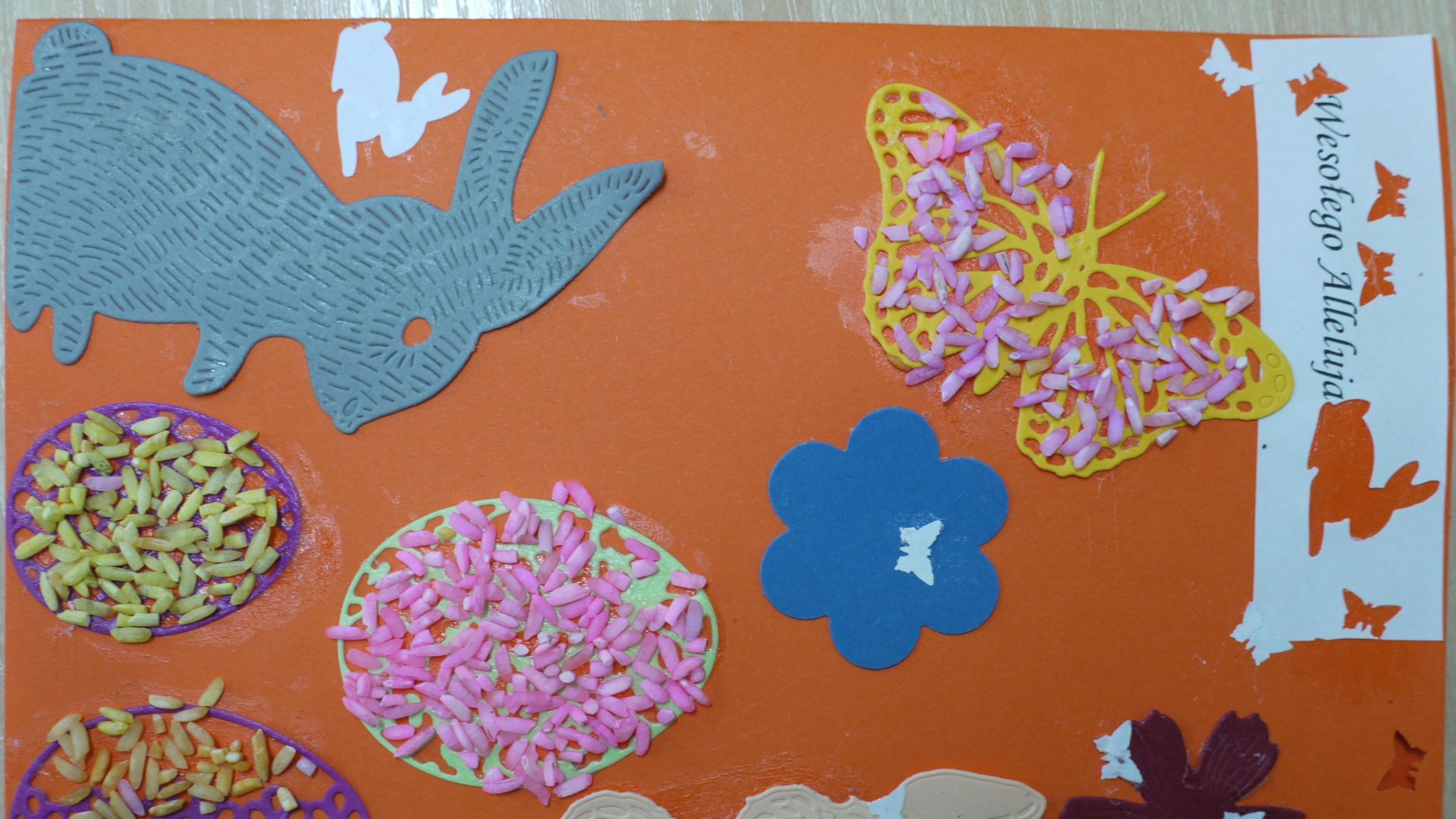 Kartka wielkanocna z zajączkami, pisankami, kwiatami i motylami. Autor: Justyna K. 