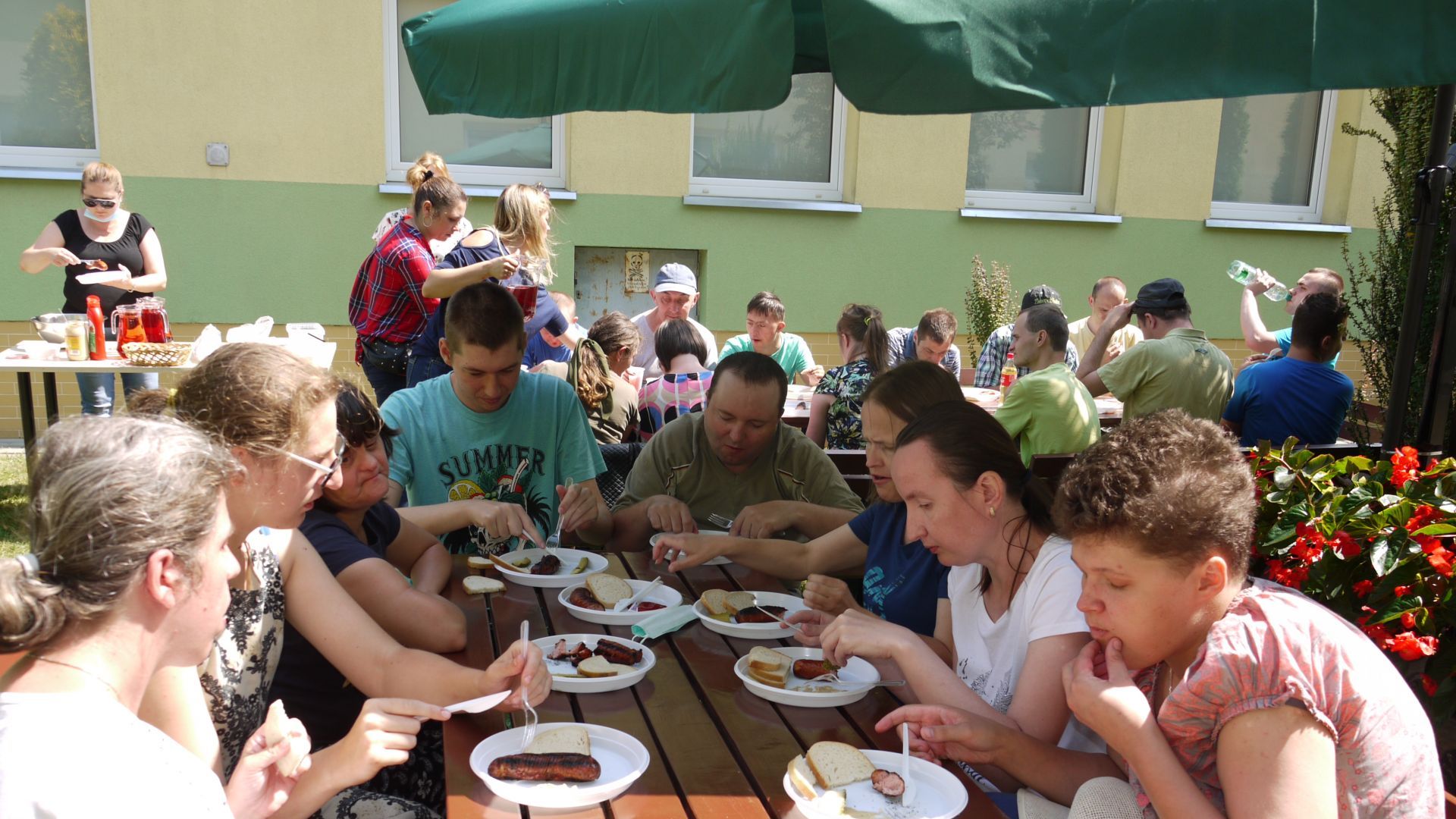 Uczestnicy przy stolikach w trakcie grilla