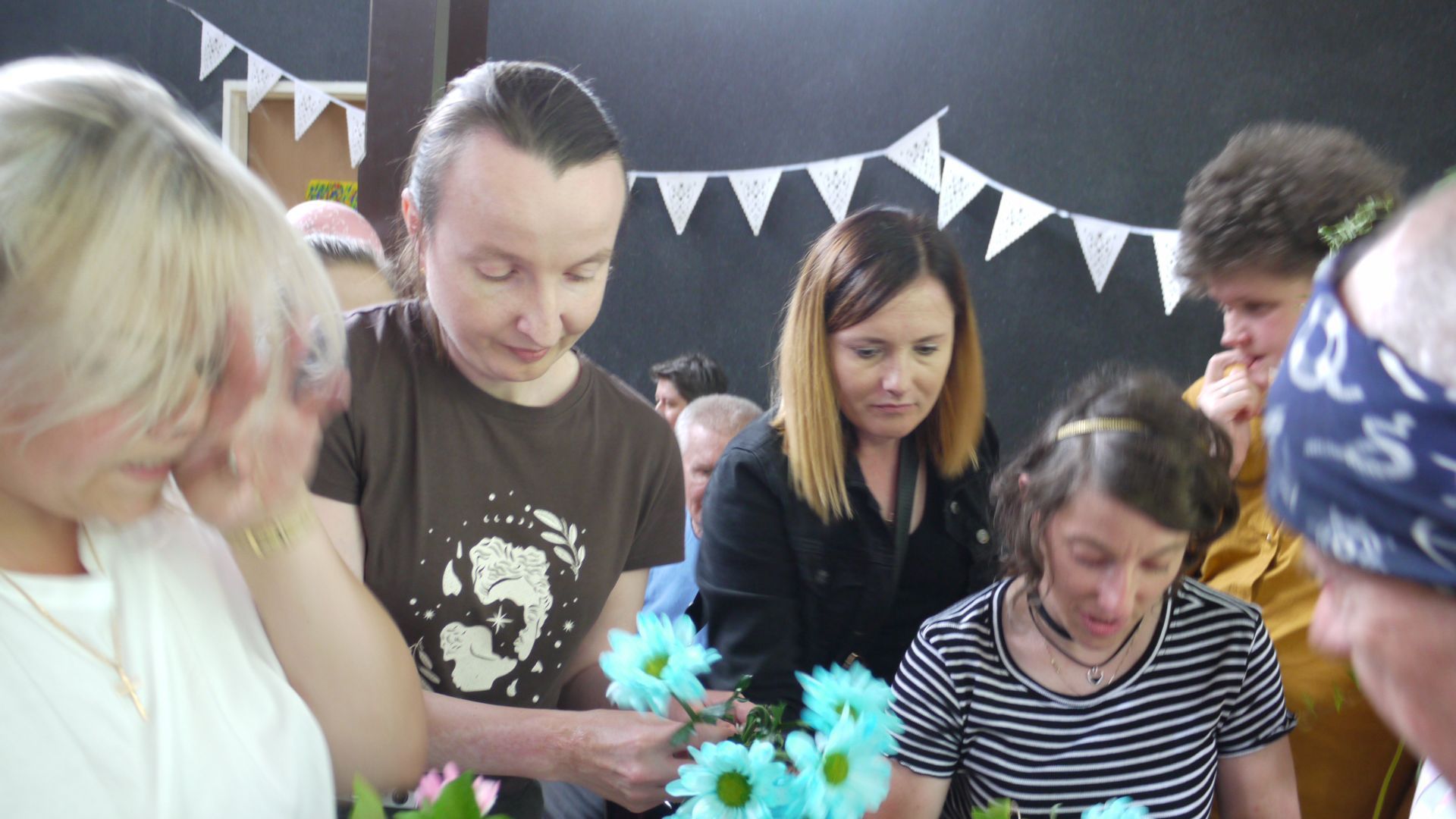 Uczestniczki dobierające kwiaty do wykonania wianków.