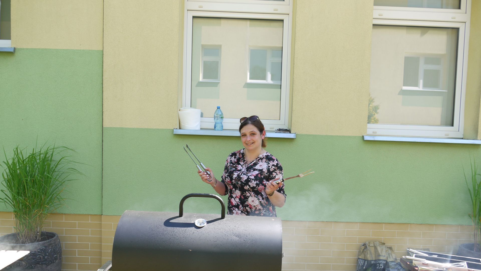 Pani Sylwia podczas pieczenia kiełbasek na grillu.
