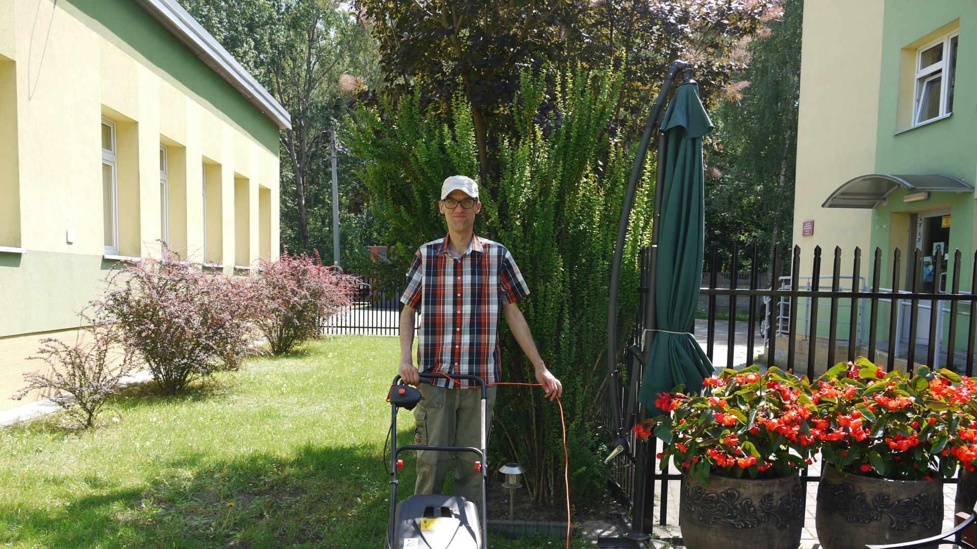 Grzegorz S. koszący trawę w ogrodzie.