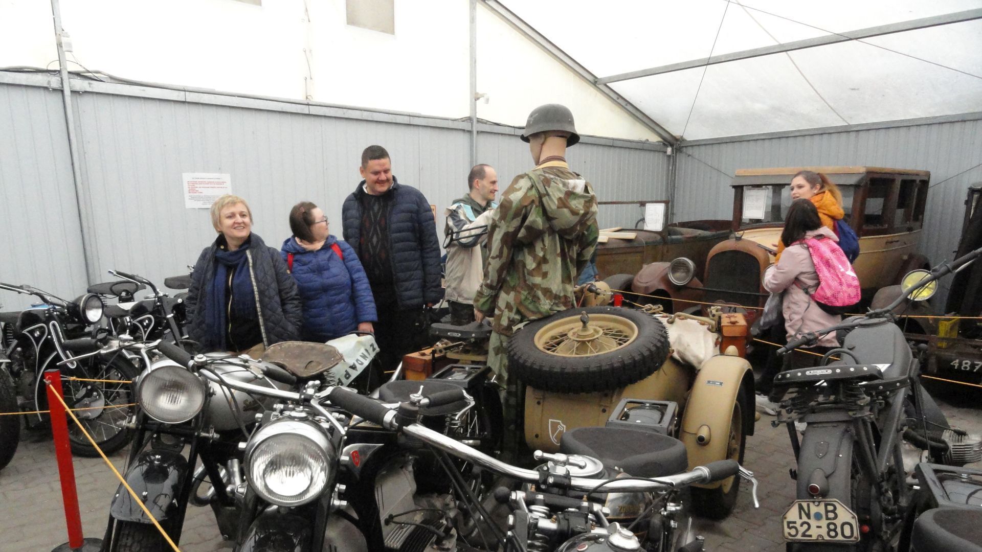 Uczestnicy wraz z panią dyrektor wśród zabytkowych motocykli w Muzeum Motoryzacji. 