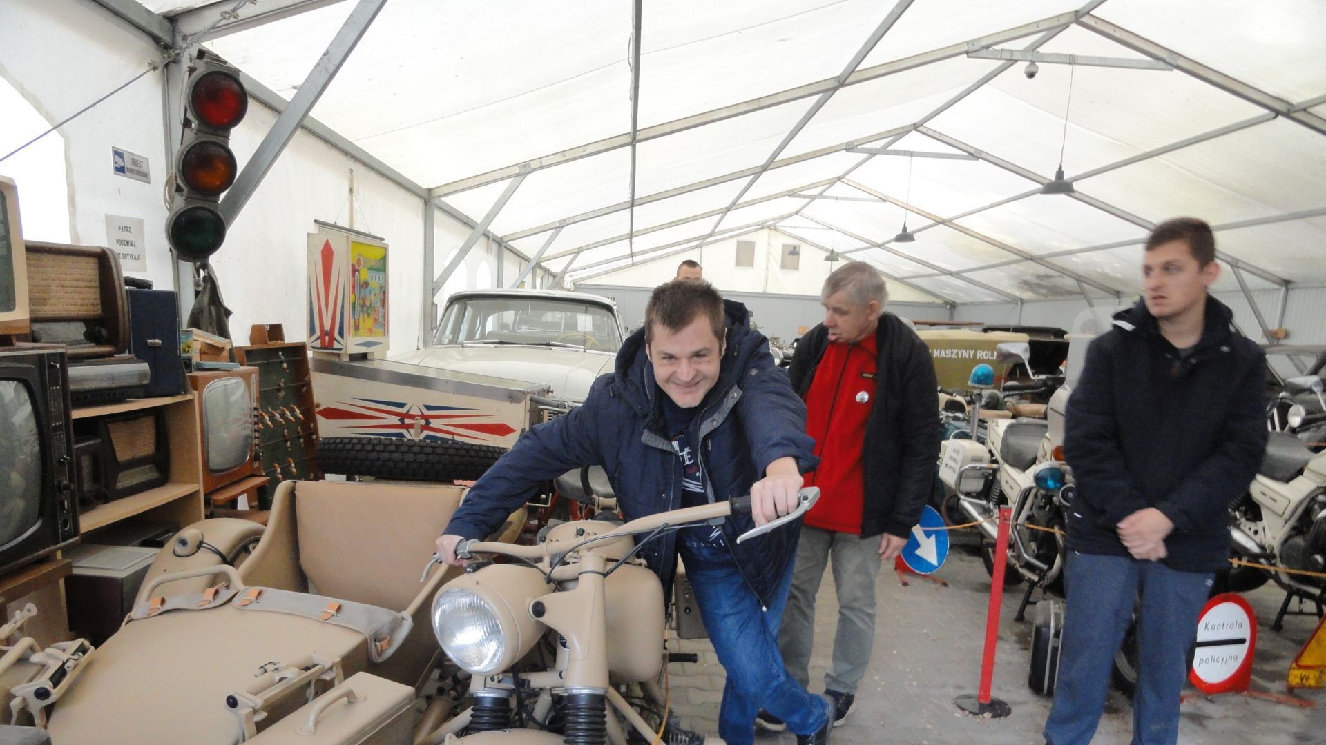 Łukasz S. stojący przy zabytkowym motocyklu.