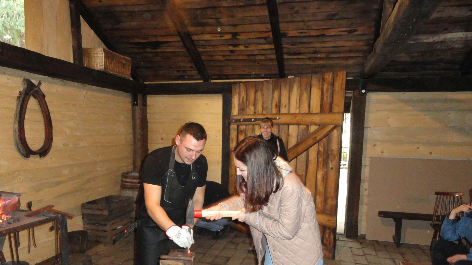 Pani Paulina Kulma wraz z instruktorem podczas wykonywania podkowy na warsztatach kowalstwa artystycznego.
