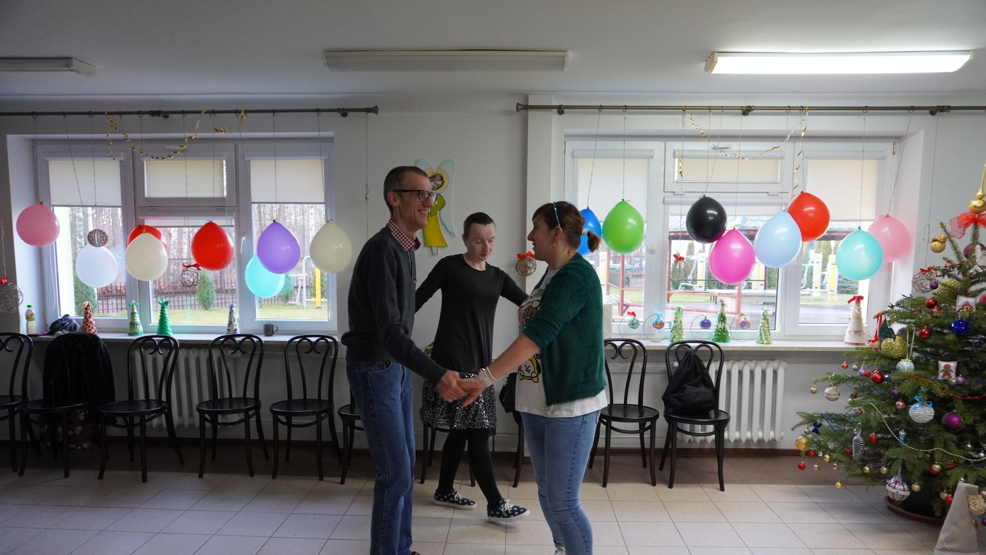 Ania, Agnieszka i Grzegorz tańczą w kółku trzymając się za ręce.