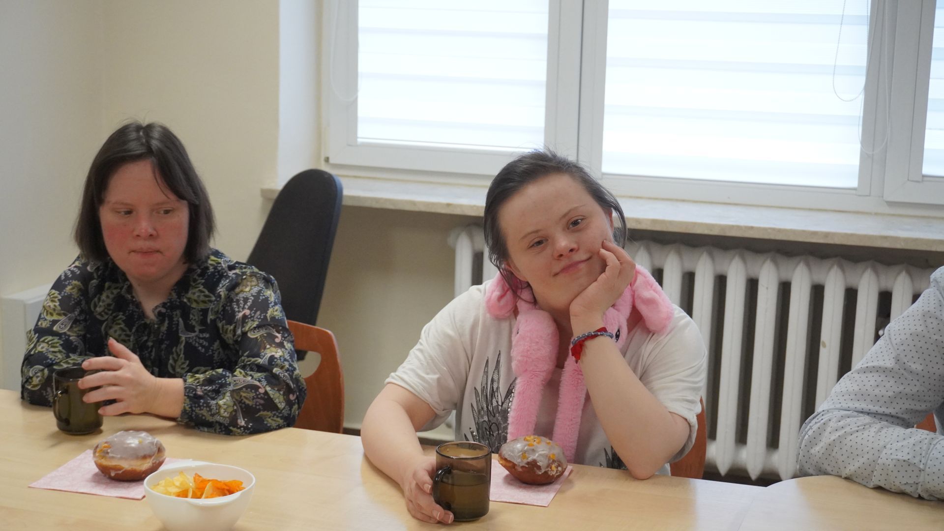 Uczestniczki Justyna i Marta podczas słodkiego poczęstunku. Przed sobą na stole mają pączki. 