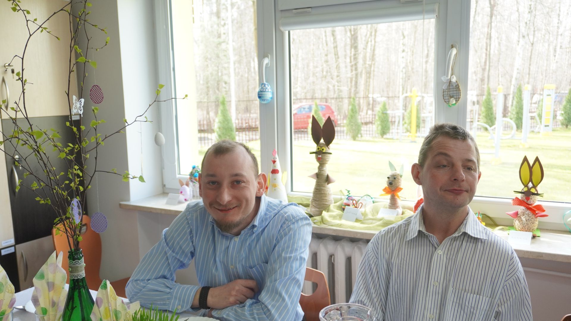 Uczestnicy Maciek i Rafał podczas spotkania wielkanocnego siedzą przy świątecznym stole. 
