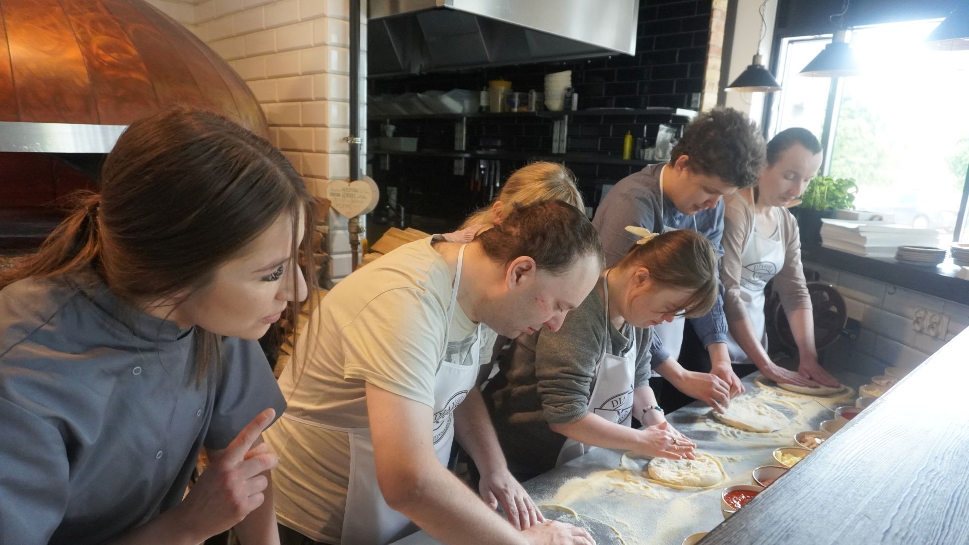 Uczestnicy przygotowują swoje pizze podczas warsztatów w pizzerii Diavola. 