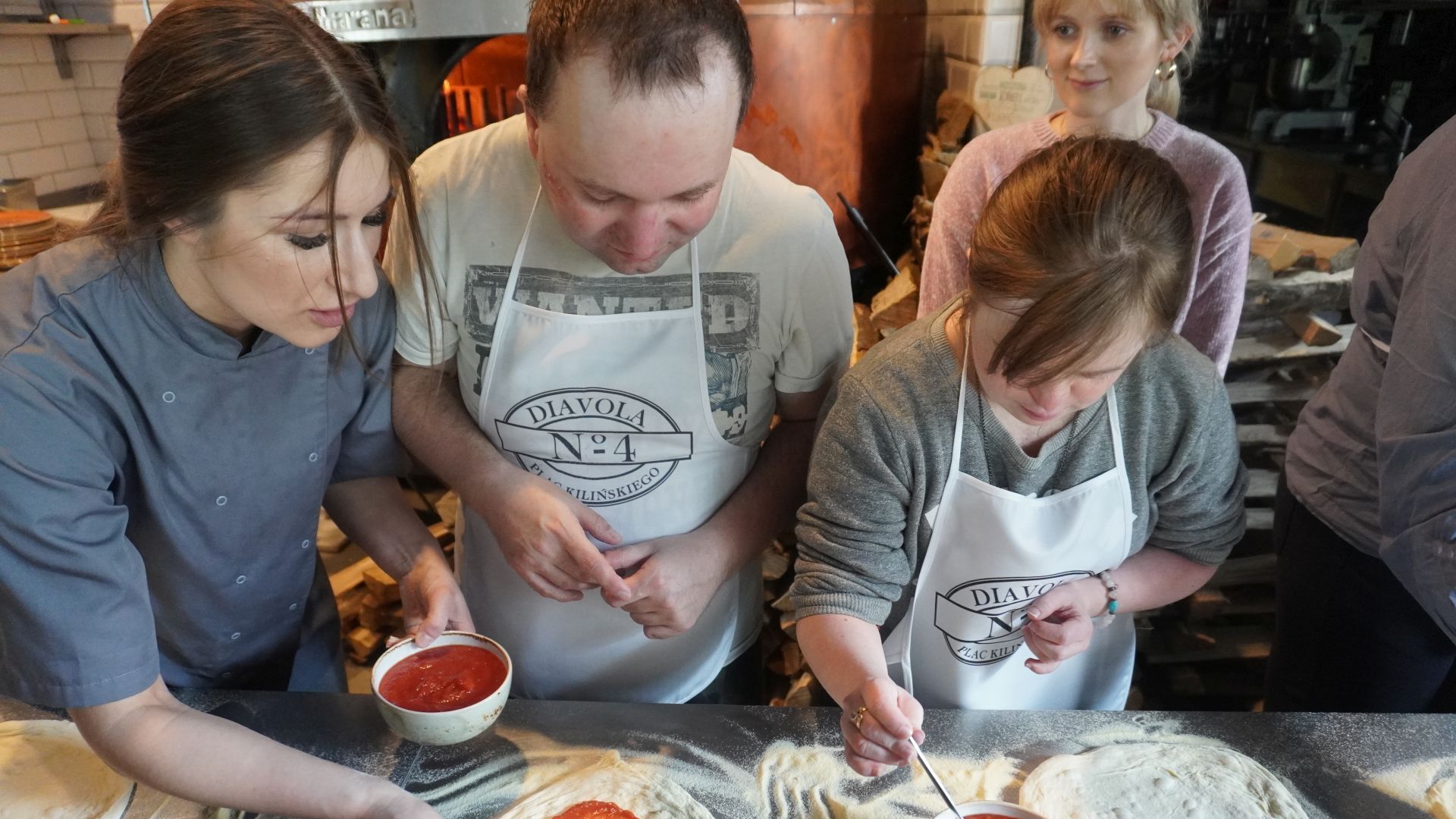 Uczestnicy przygotowują swoje pizze podczas warsztatów w pizzerii Diavola. 