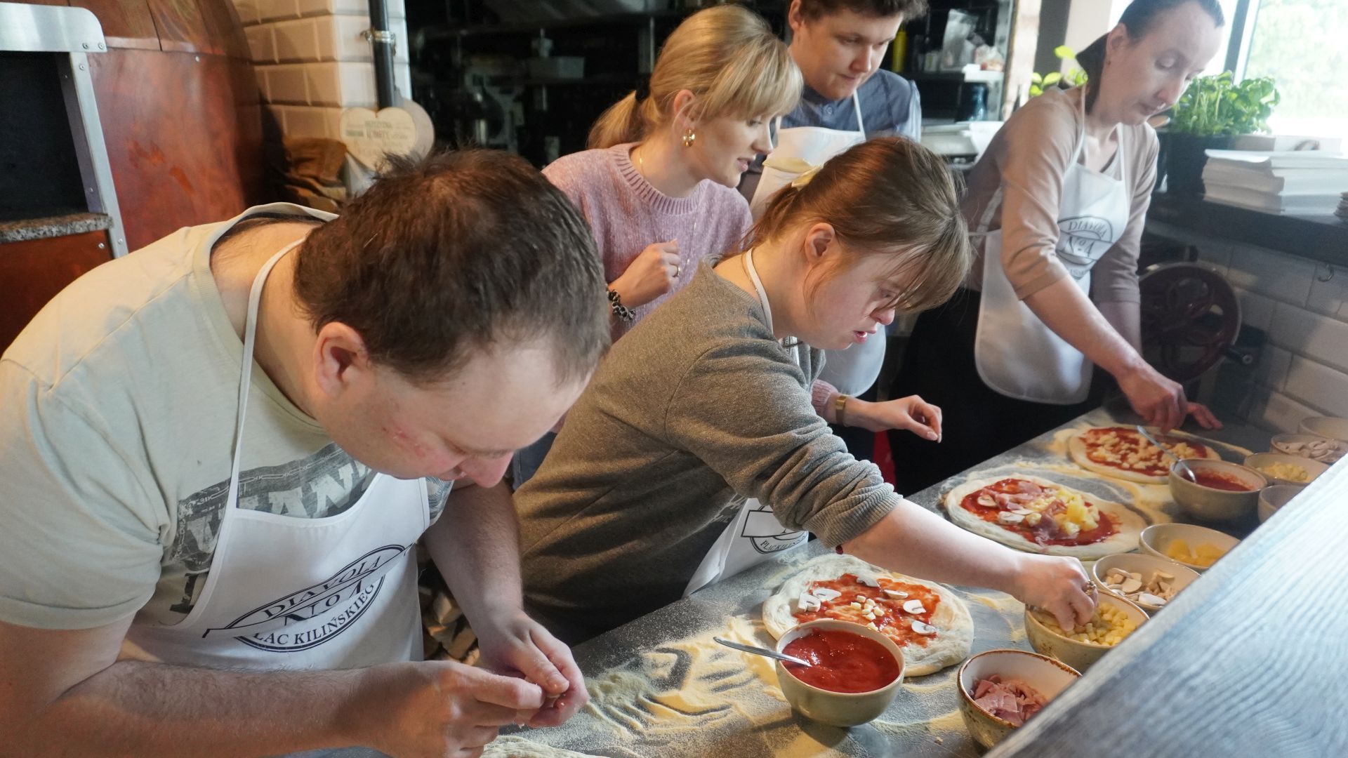 Uczestnicy przygotowują swoje pizze podczas warsztatów w pizzerii Diavola. 