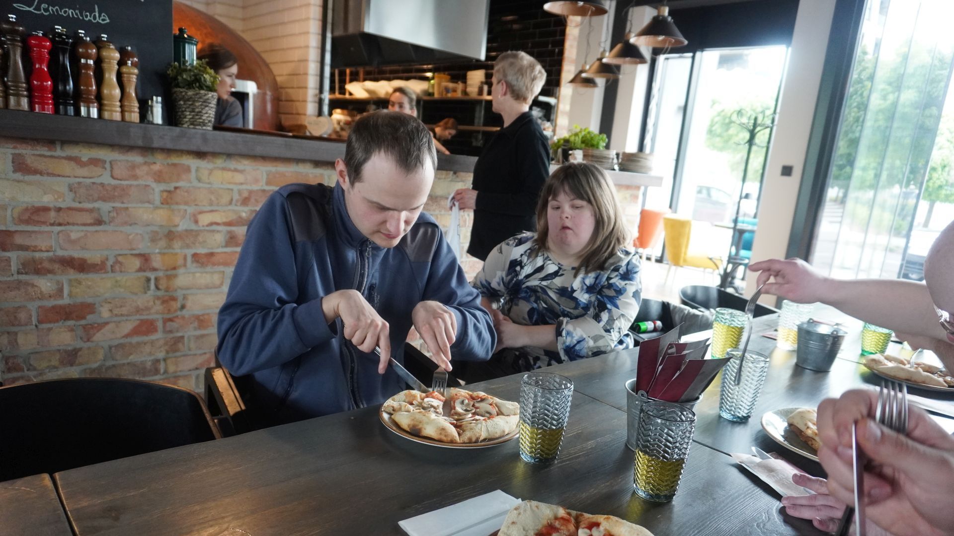 Uczestnicy jedzą przygotowane przez siebie pizze podczas warsztatów w pizzerii Diavola.