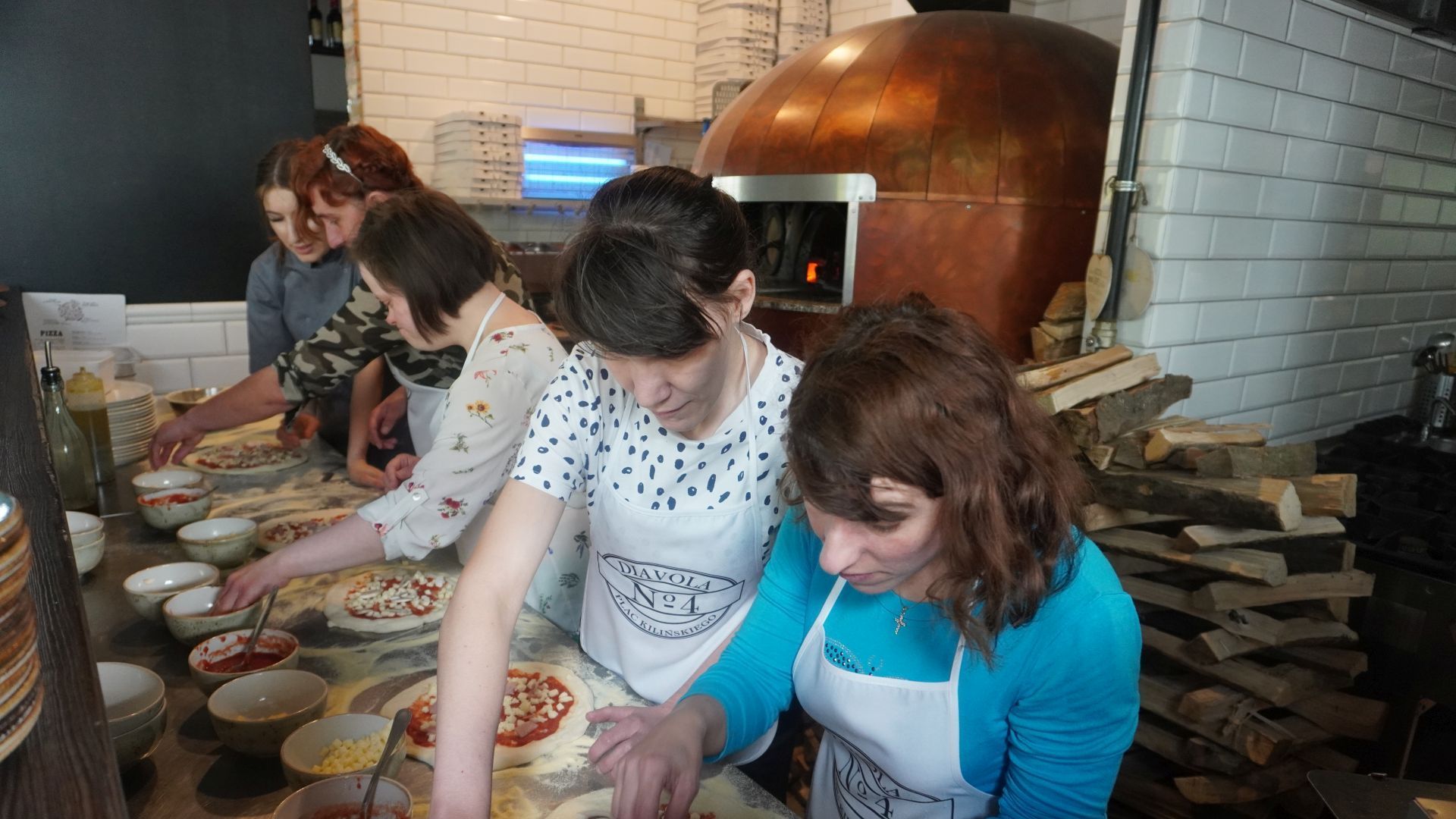Uczestniczki przygotowują swoje pizze podczas warsztatów w pizzerii Diavola. 