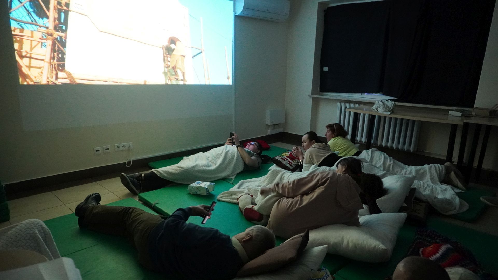 Uczestnicy oglądają film podczas wieczornych zajęć integracyjnych.