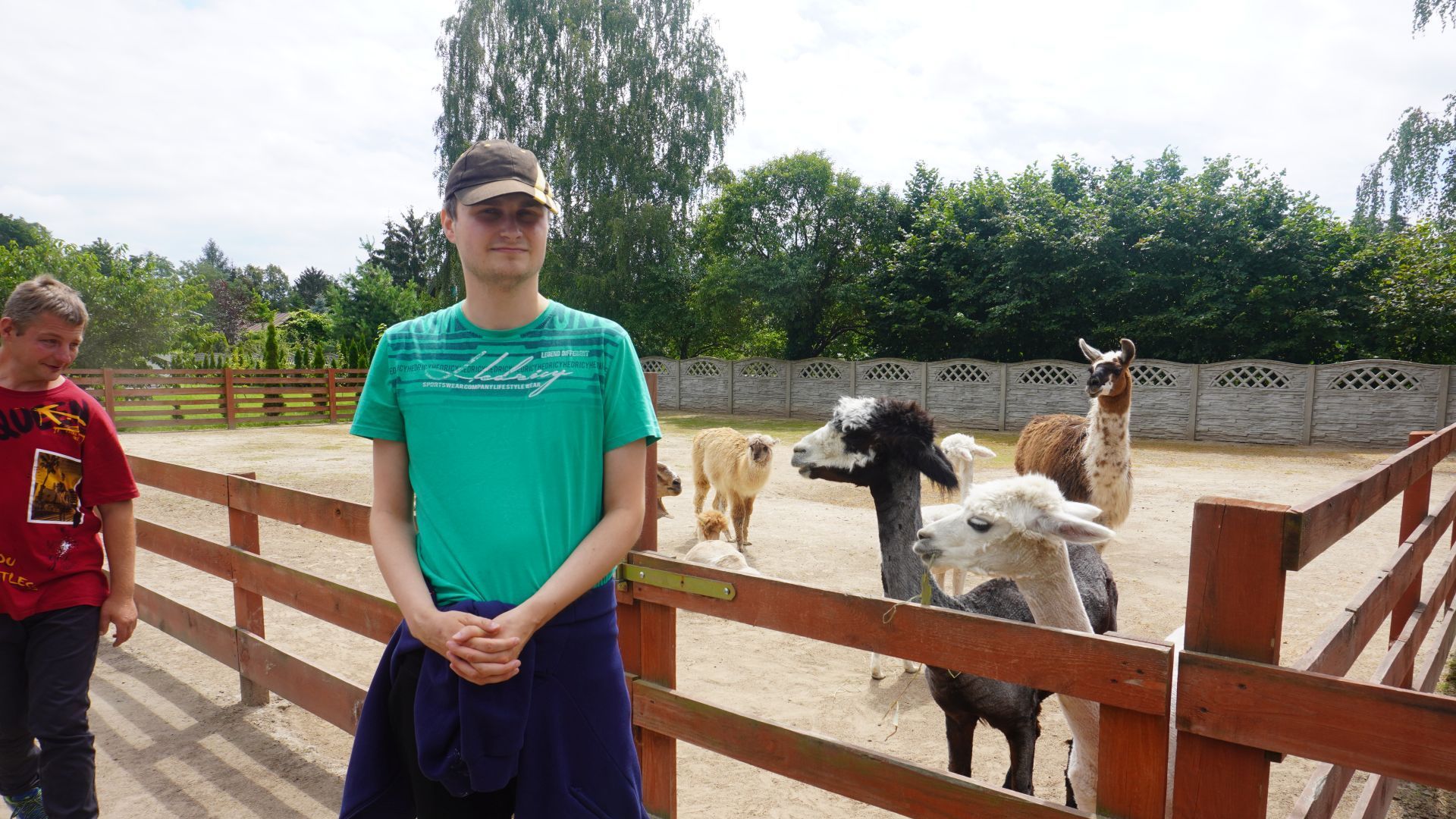 Uczestnik Krzysztof pozuje do zdjęcia z lamami w Mini Zoo na ''Farmie Goławice''.