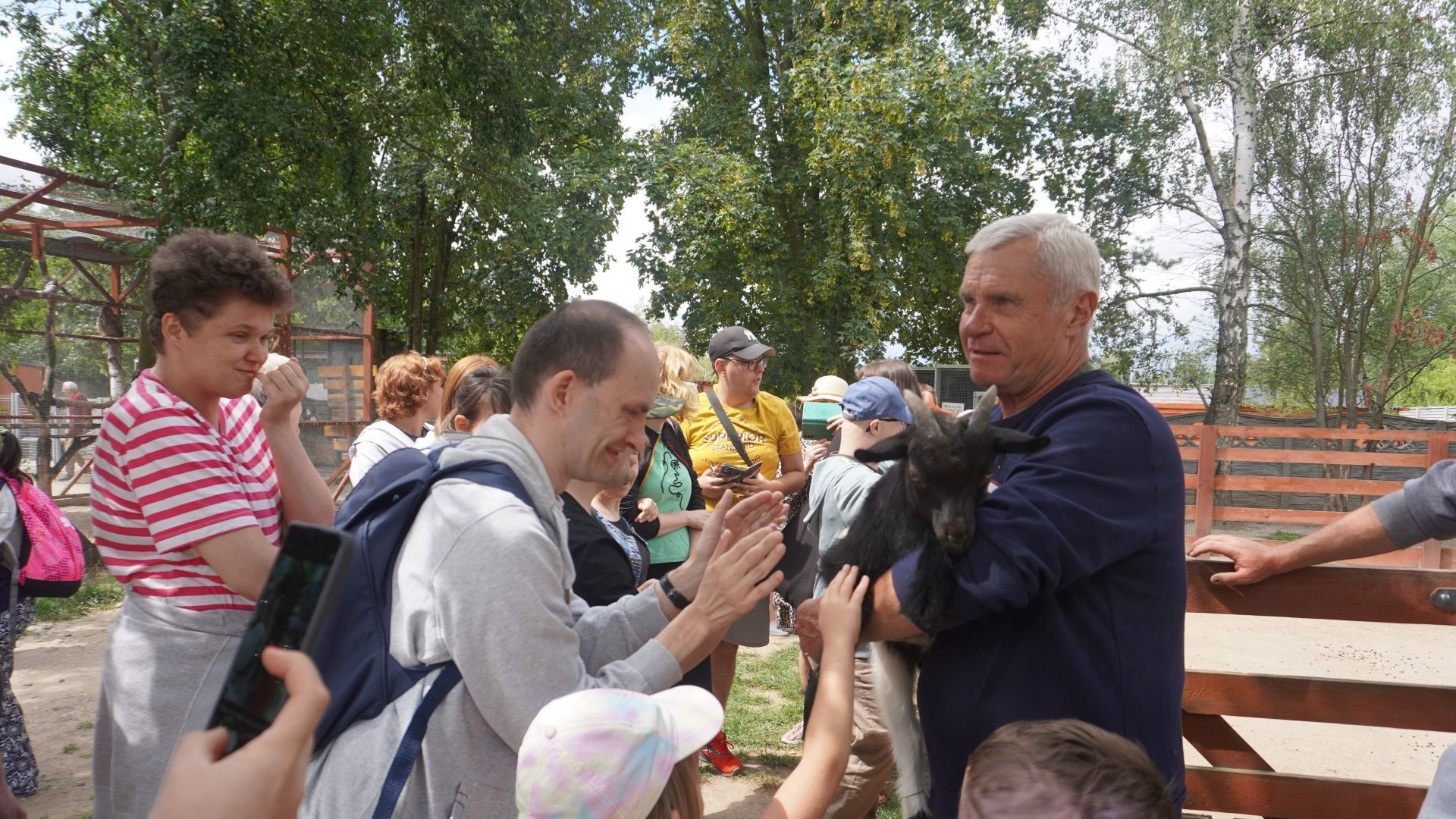 Przewodnik pokazuje mini kozę podczas zwiedzania Mini Zoo na ''Farmie Goławice''.