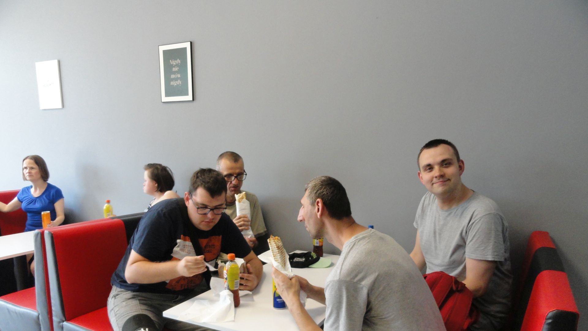 Uczestnicy jedzą kebaby w restauracji. 