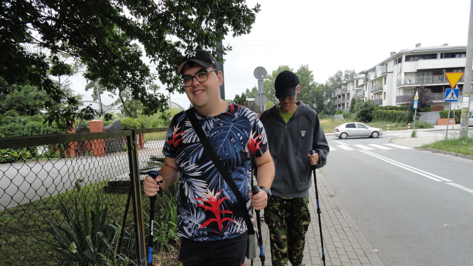 Uczestnicy Karol i Grzegorz maszerują z kijkami nordic walking.
