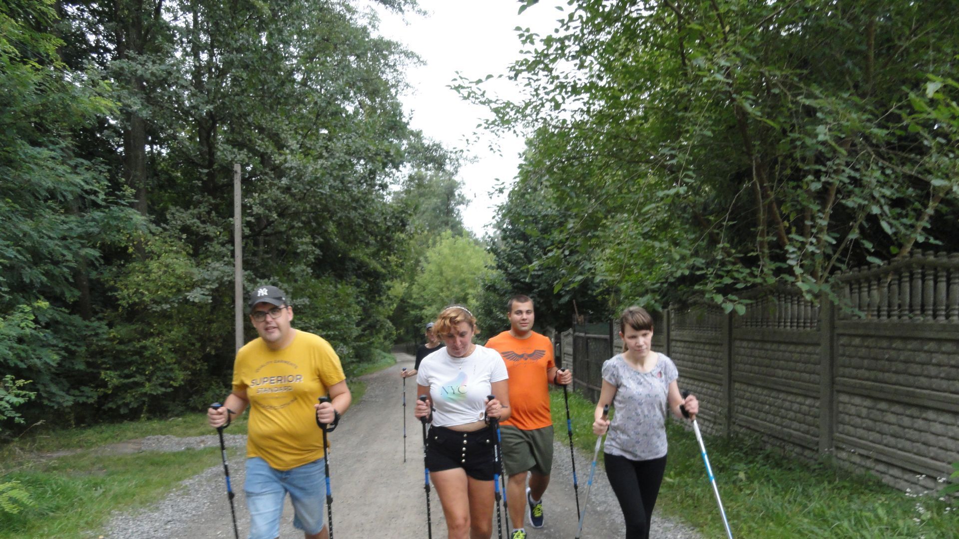 Uczestnicy maszerują z kijkami nordic walking. 