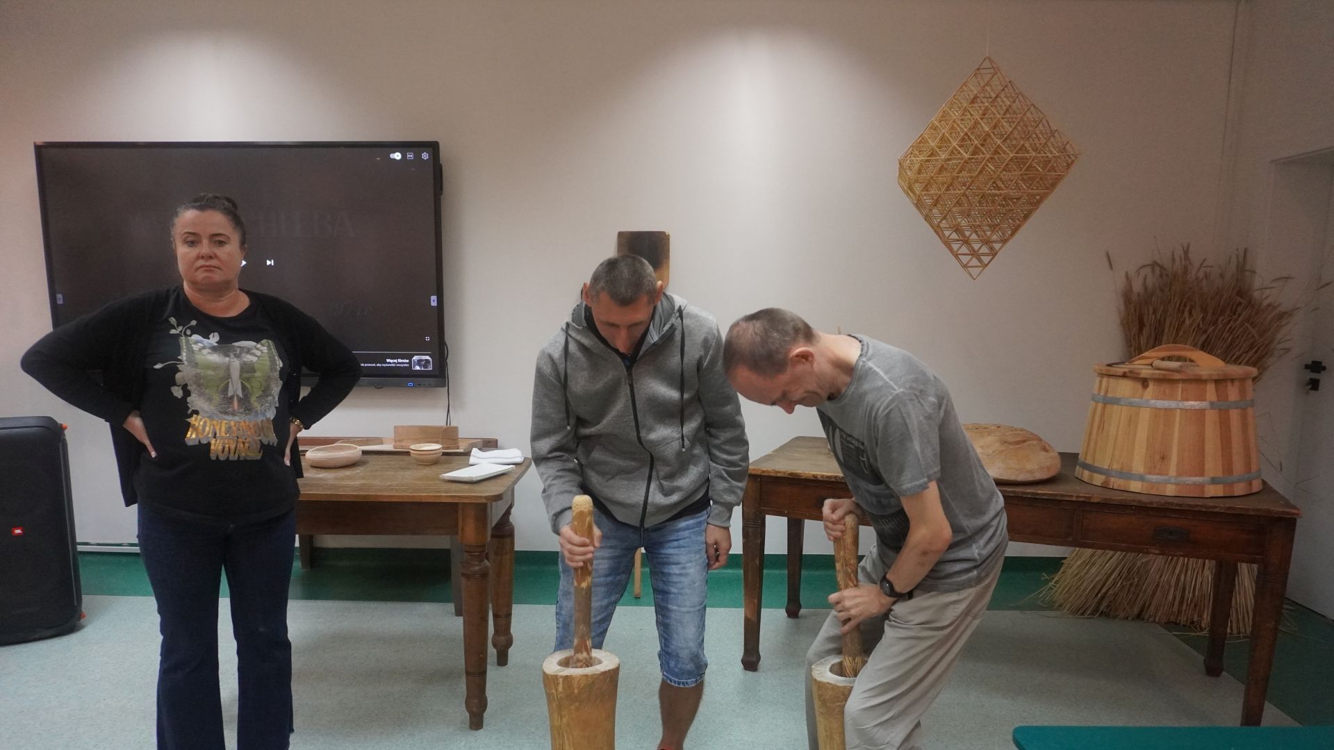 Uczestnicy Sebastian i Paweł podczas warsztatów ''Od ziarenka do bochenka'' rozbijają ziarna zbóż, aby pozyskać z nich mąkę. 