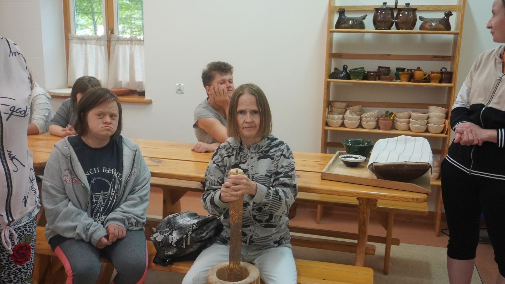 Uczestniczka podczas warsztatów ''Od ziarenka do bochenka'' rozbija ziarna zbóż, aby pozyskać z nich mąkę. 