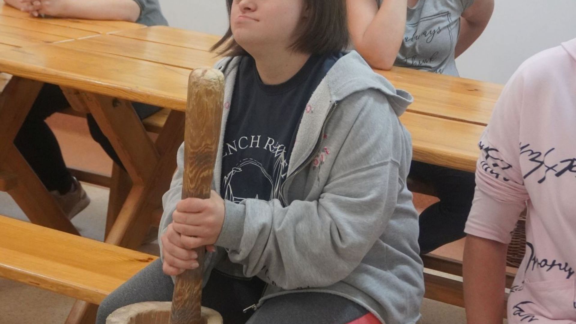 Uczestniczka Marta podczas warsztatów ''Od ziarenka do bochenka'' rozbija ziarna zbóż, aby pozyskać z nich mąkę. 