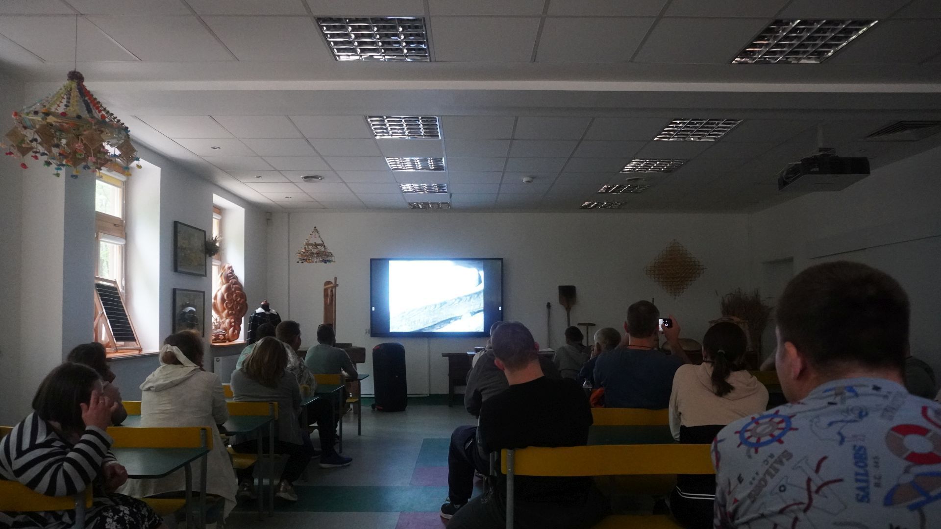 Uczestnicy oglądają film podczas warsztatów ''Od ziarenka do bochenka'' w Muzeum Wsi Radomskiej.