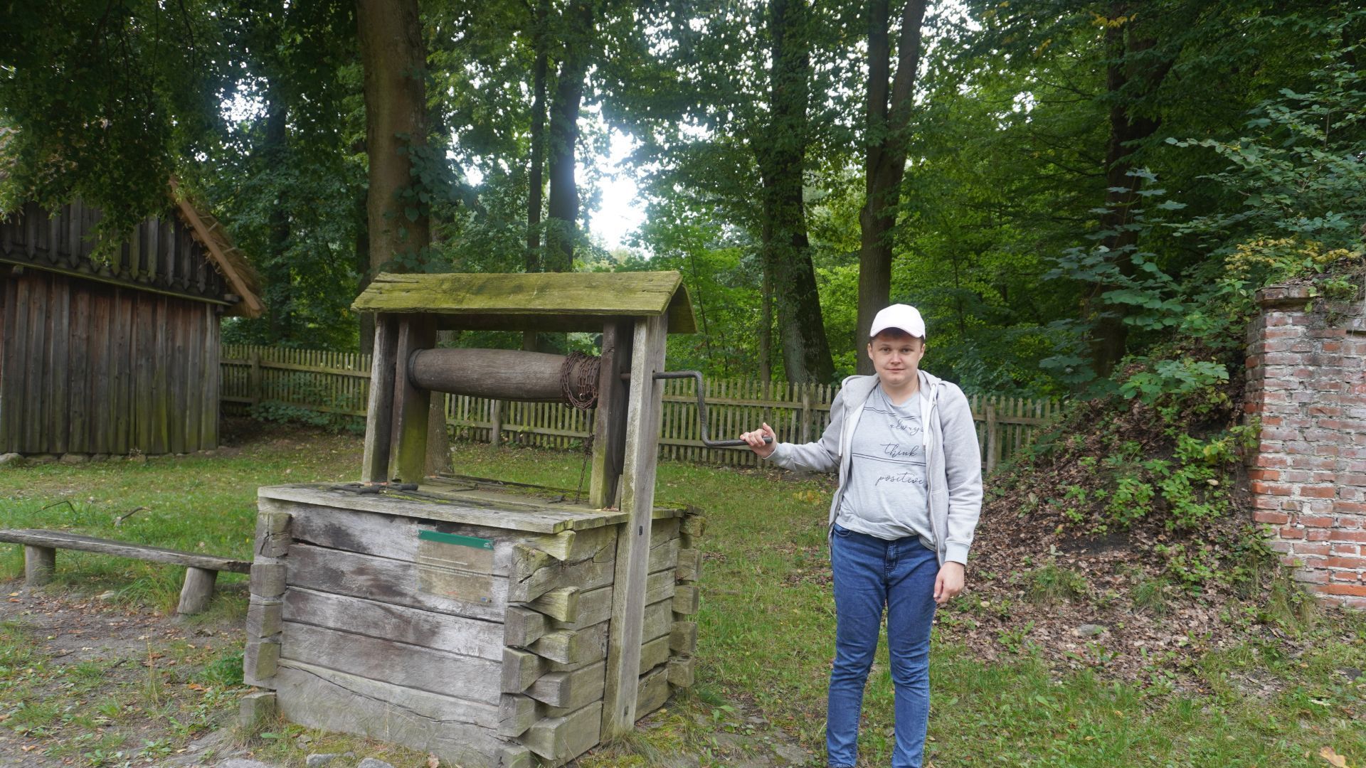Uczestniczka Aneta stoi przy starej studni w Muzeum Wsi Radomskiej.