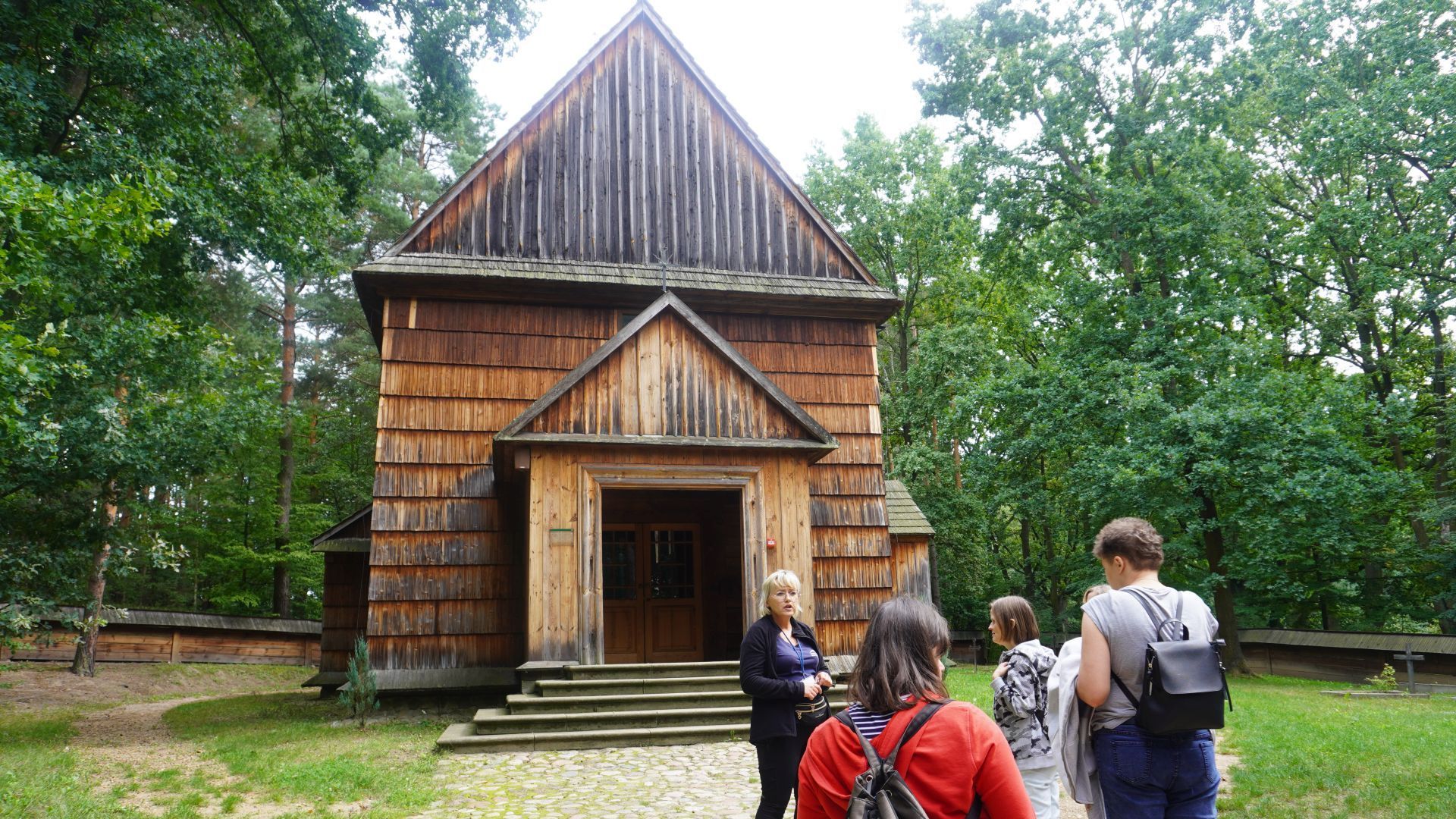 Uczestniczki przed XVIII-wiecznym kościołem z Wolanowa w Muzeum Wsi Radomskiej. 