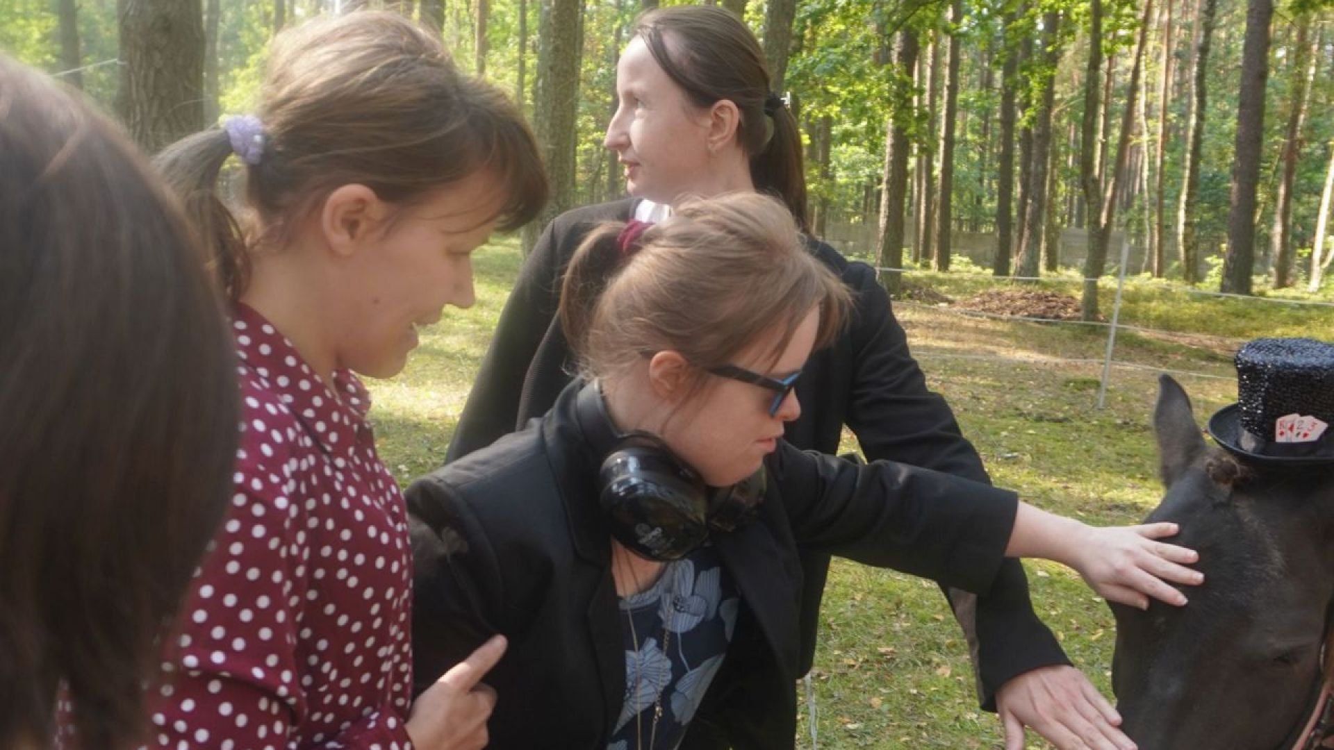 Uczestniczka Martyna głaszcze kucyka podczas plenerowej imprezy integracyjnej ''Jedlina w Krainie Czarów''.
