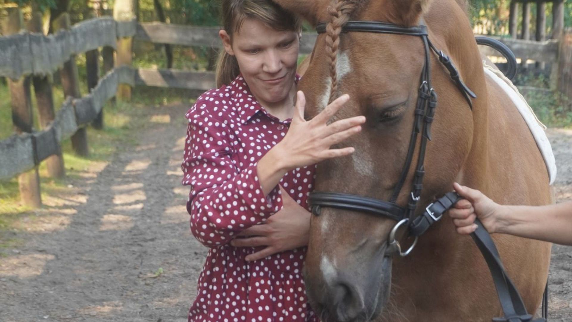 Uczestniczka Małgosia głaszcze kucyka podczas plenerowej imprezy integracyjnej ''Jedlina w Krainie Czarów''.