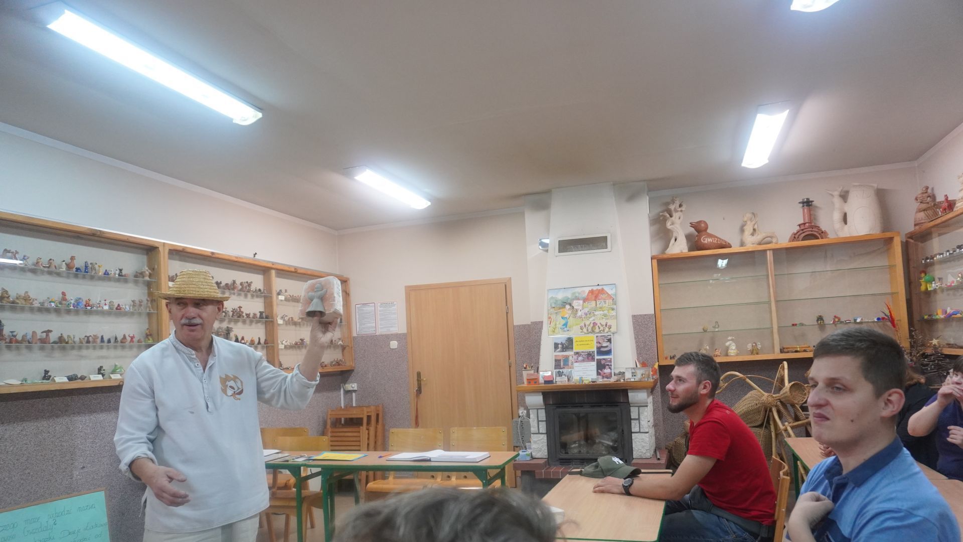 Kustosz muzeum pokazuje uczestnikom wyrób z gliny podczas wizyty w Muzeum Gwizdka w Gwizdałach.