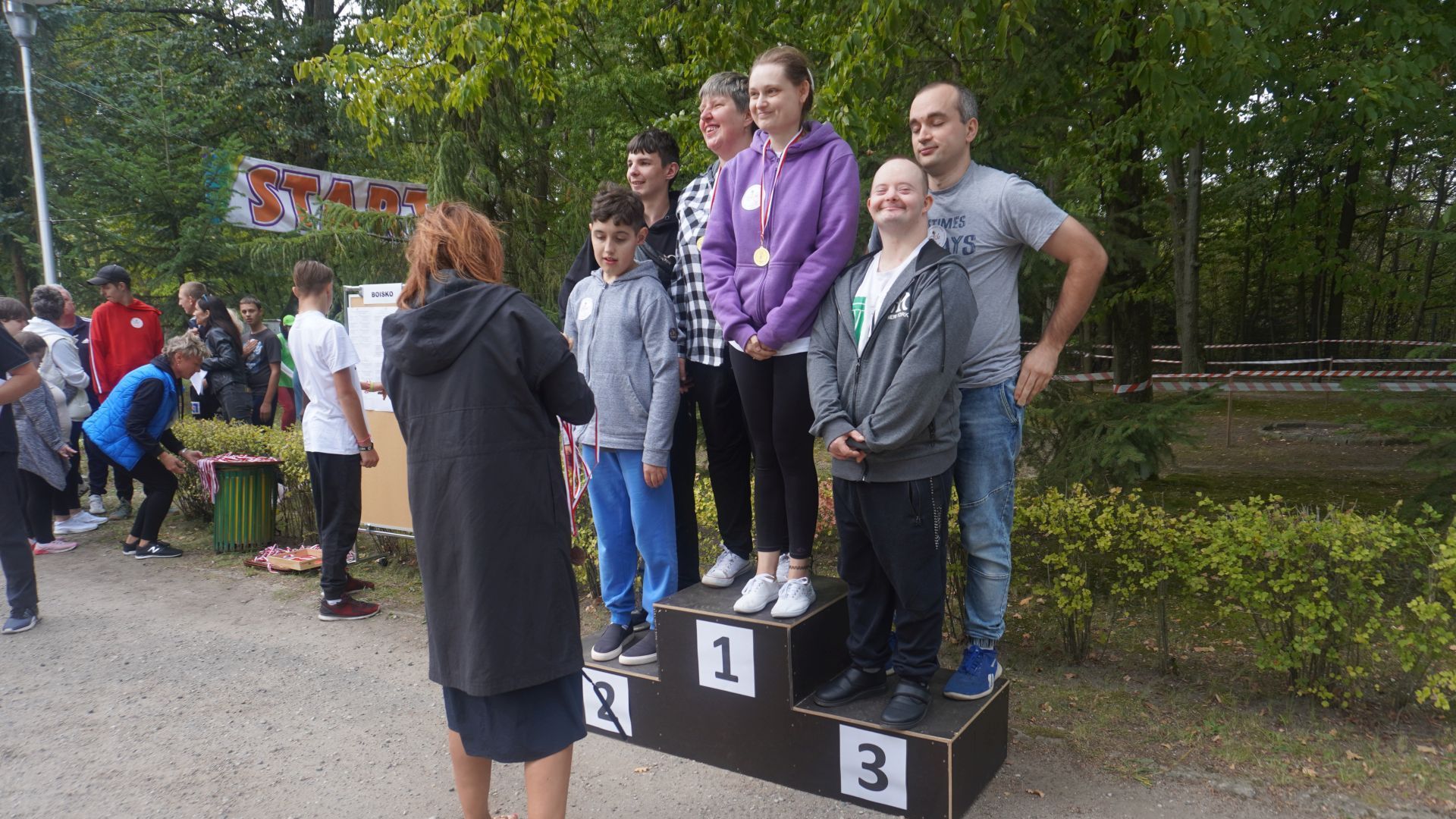Zawodnicy grający w piłkarzyki stołowe stoją na podium. 