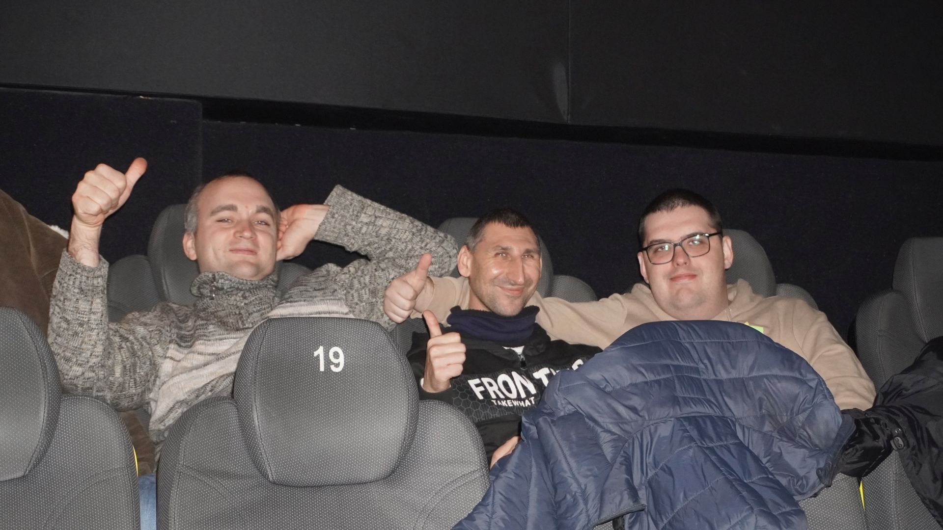 Konrad, Sebastian oraz Karol pozują do zdjęcia w sali kinowej podczas oczekiwania na film ''U Pana Boga w Królowym Moście''.