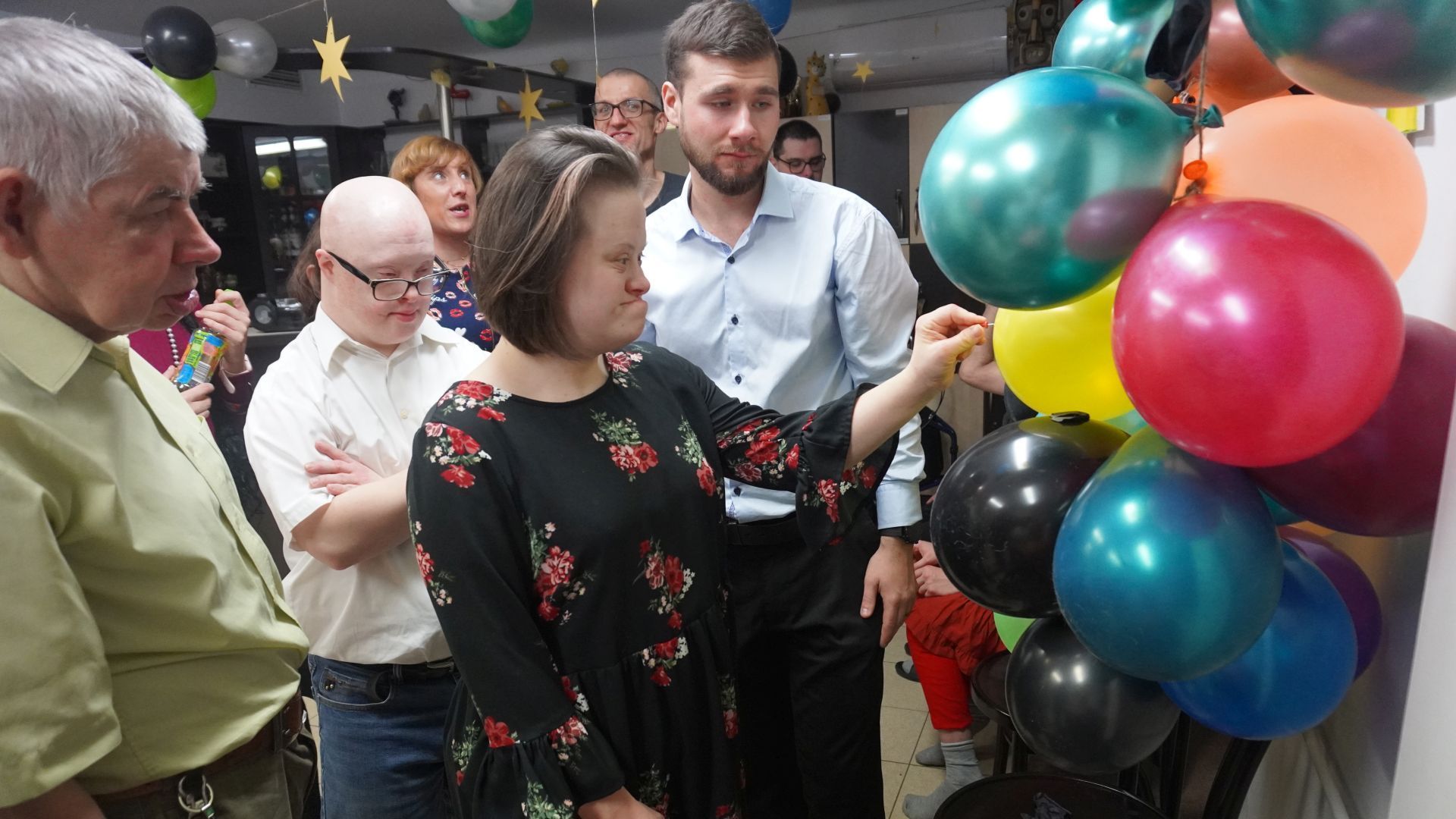 Uczestniczka Marta przebija balon, w którym jest ukryta wróżba andrzejkowa.