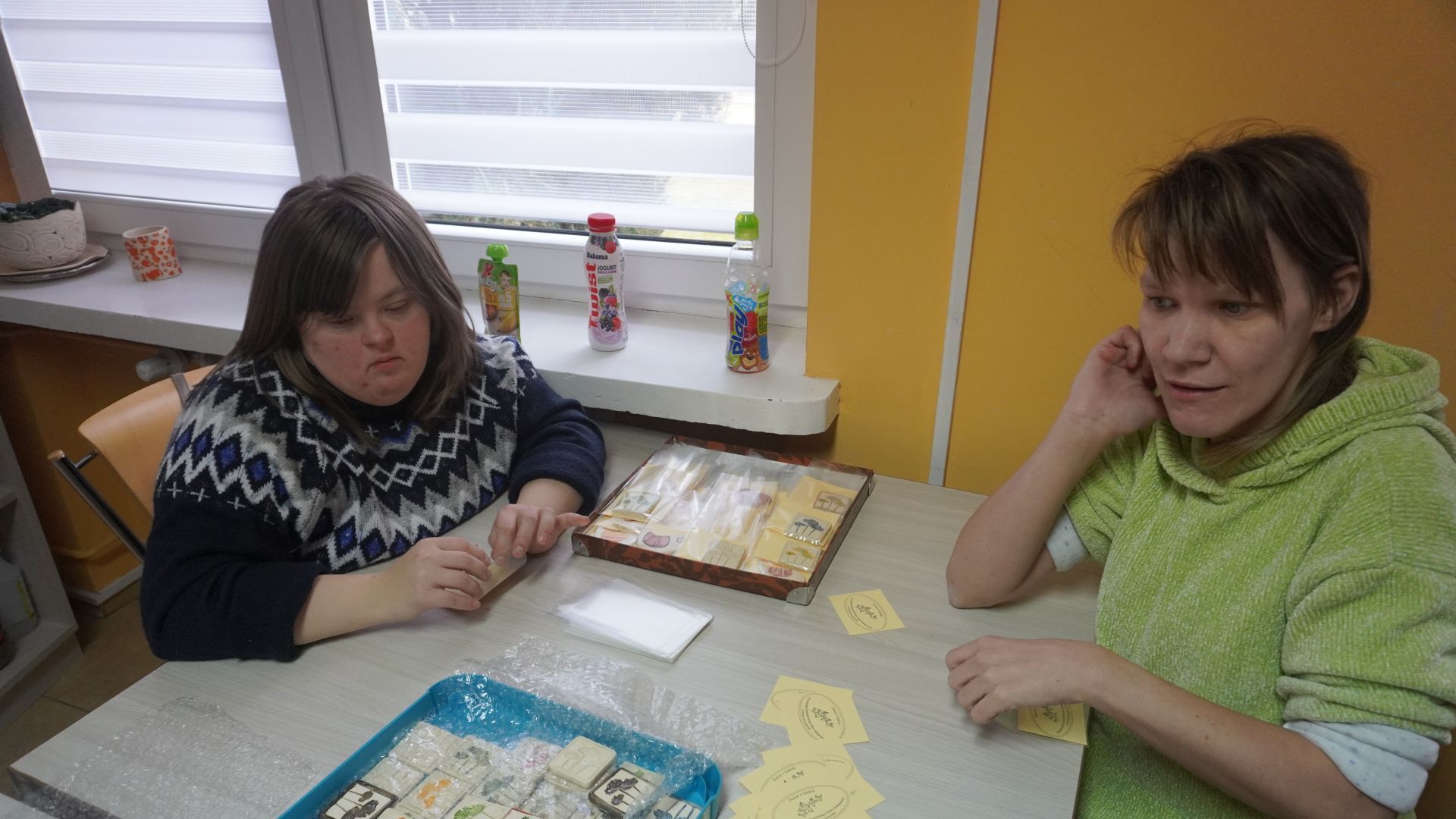 Uczestniczki Małgosia i Sylwia pakują magnesy ceramiczne na 50-lecie Medycznej Szkoły Policealnej w Mińsku Mazowieckim.