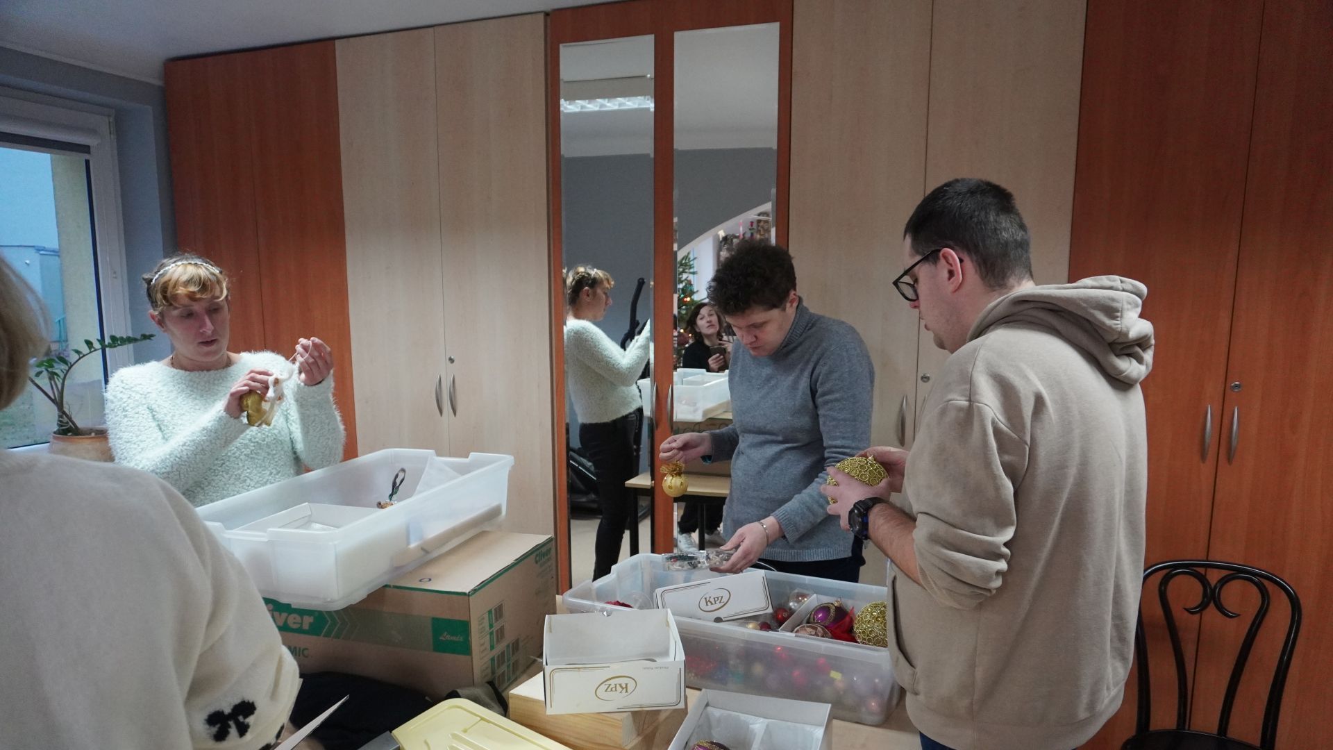 Uczestnicy wybierają ozdoby, które będą zawieszać na choince.