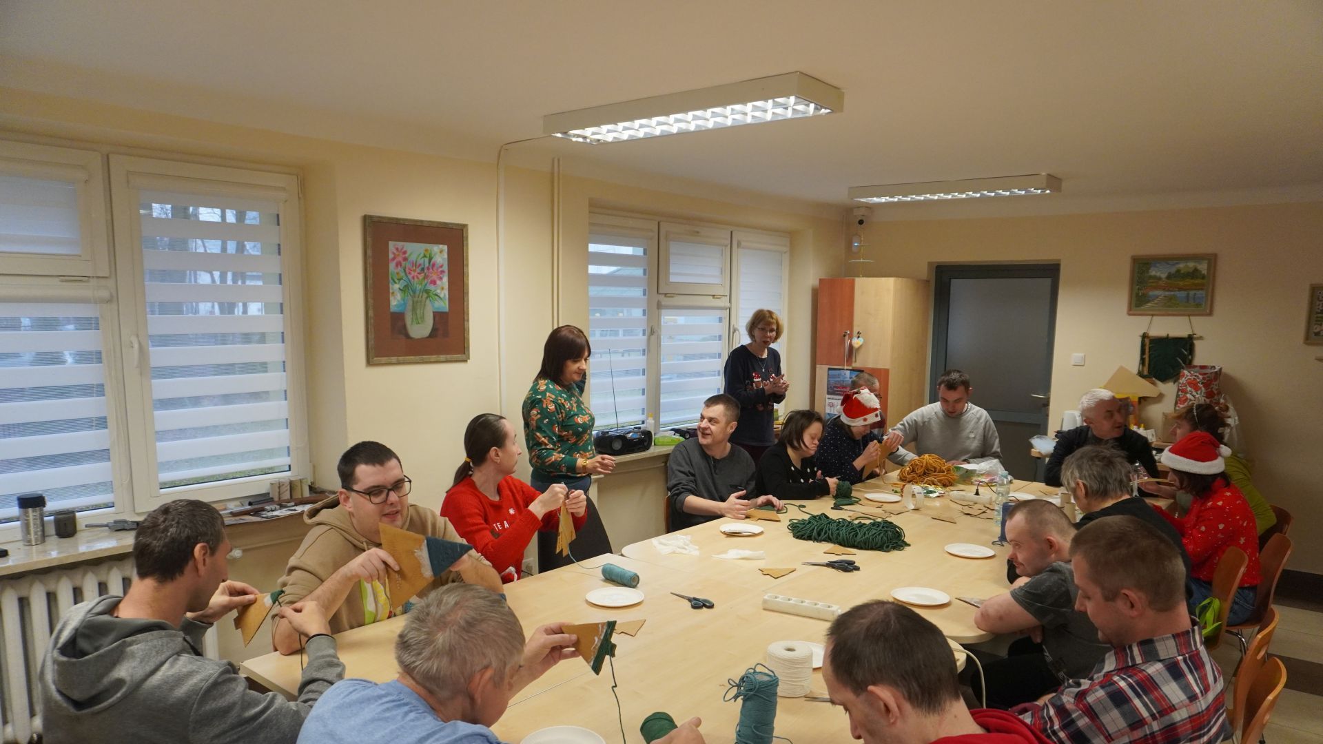 Uczestnicy wykonują ozdoby bożonarodzeniowe podczas warsztatów świątecznych. 