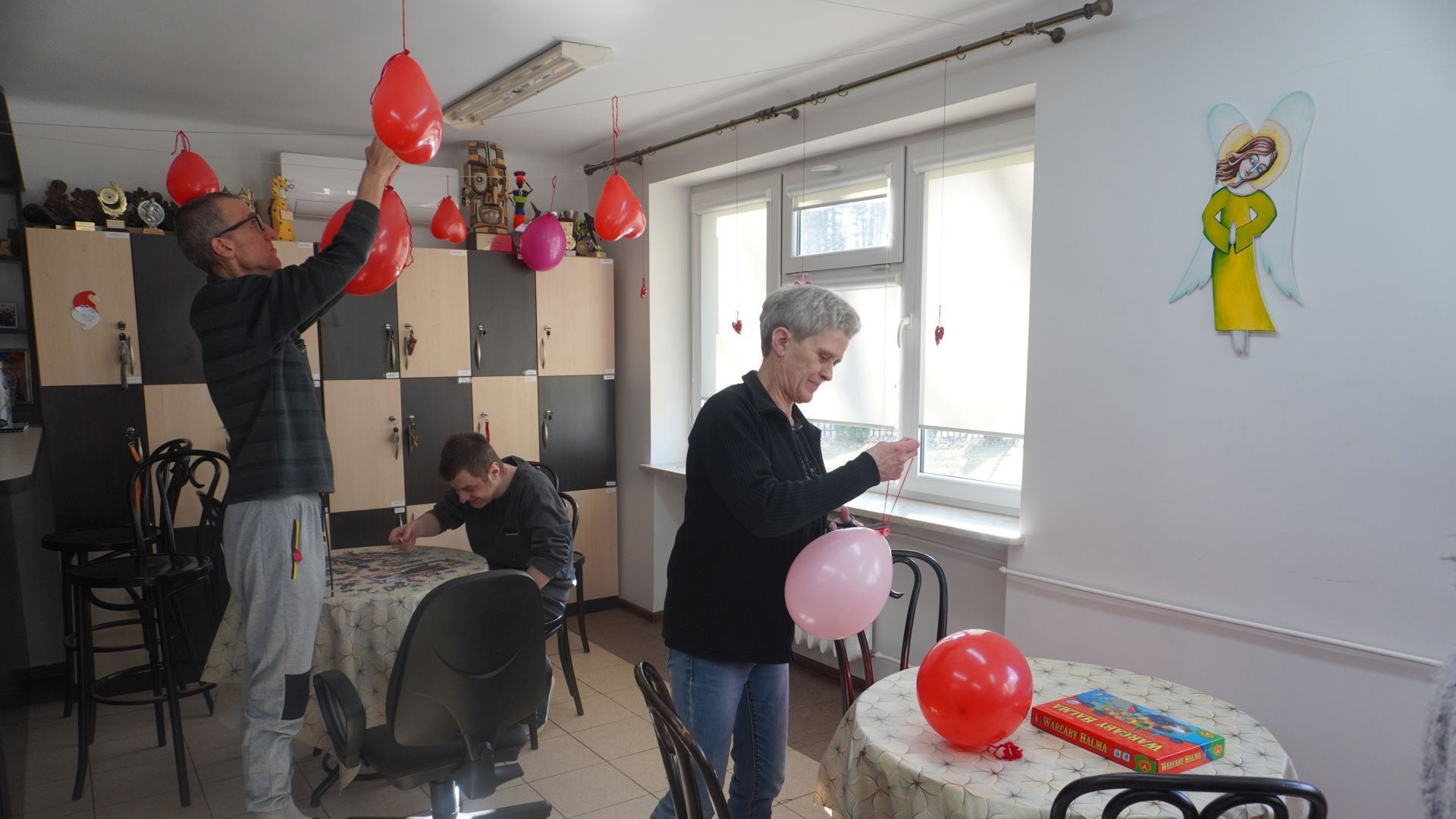 Zawieszanie balonów i dekorowanie Art.-kawiarni na Walentynki.
