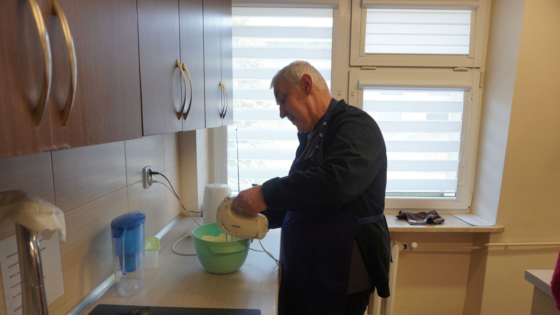 Uczestnik Tadeusz miksuje śmietanę na ciastka z okazji walentynek.