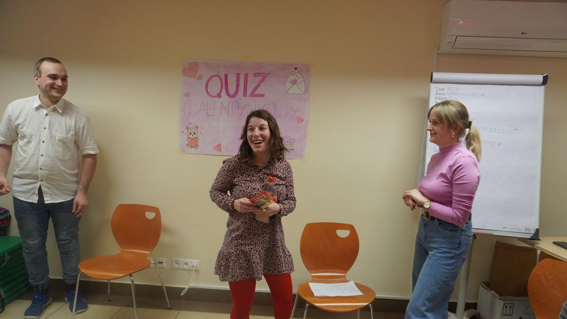 Uczestniczka Justyna K. otrzymuje czekoladę za największą wiedzę w quizie walentynkowym.