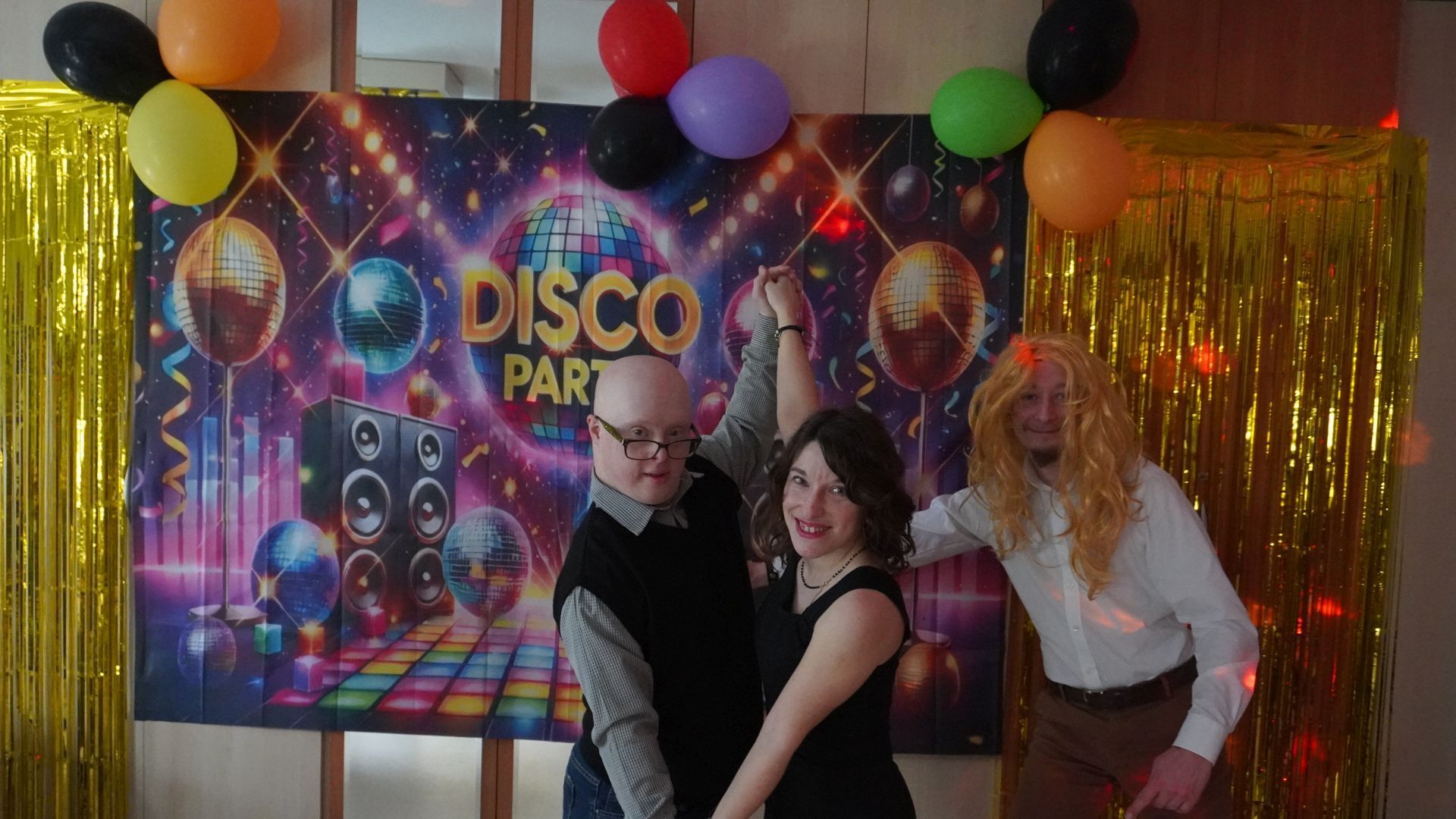 Uczestnicy Mateusz, Justyna i Maciek pozują do zdjęcia na ściance z napisem Disco Party.