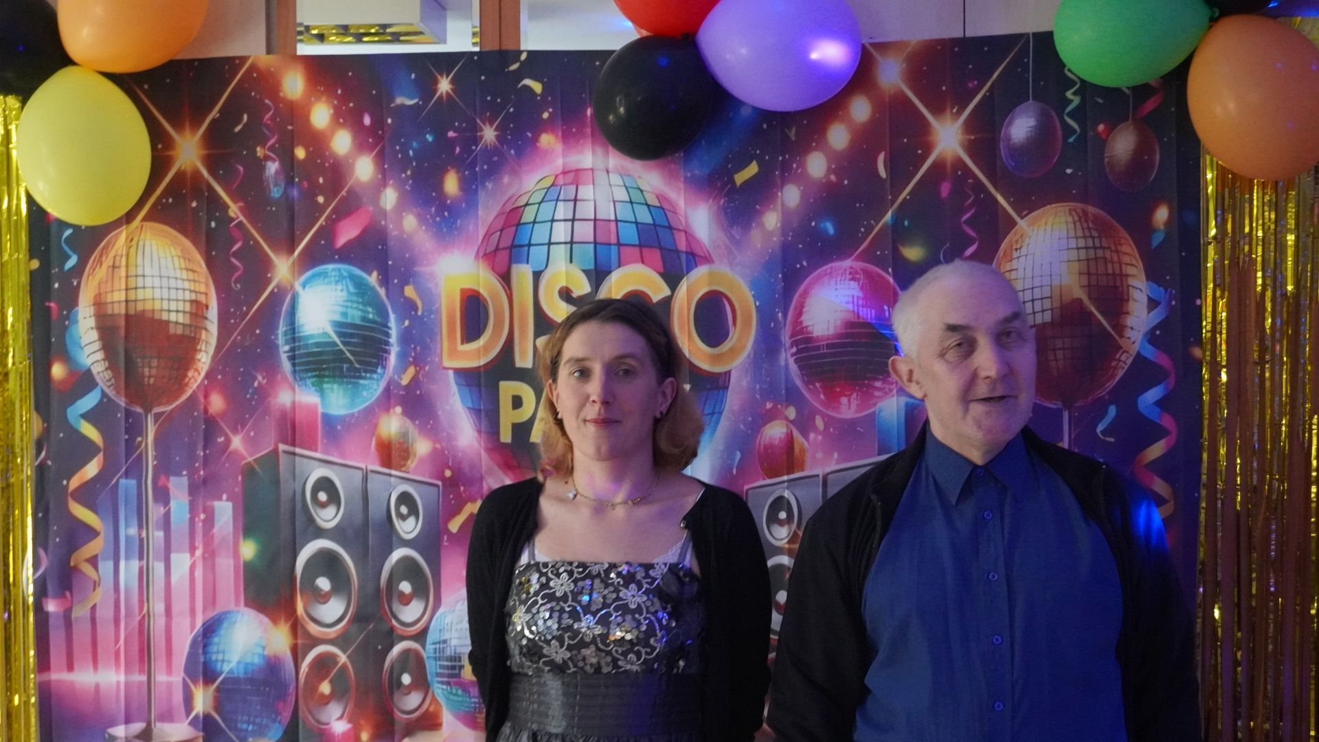 Uczestnicy Agnieszka W. i Tadeusz pozują do zdjęcia na ściance z napisem Disco Party.