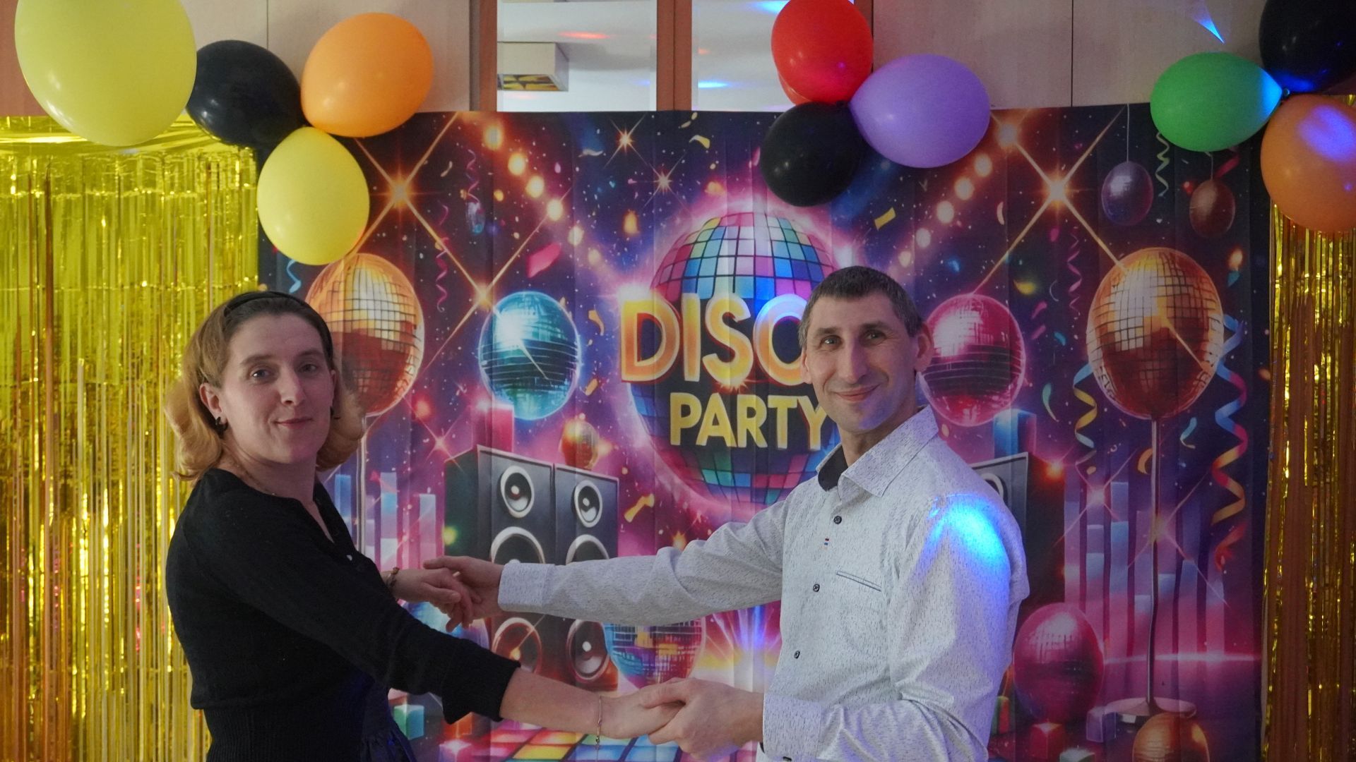 Uczestnicy Agnieszka W. i Sebastian pozują razem na ściance z napisem Disco Party.