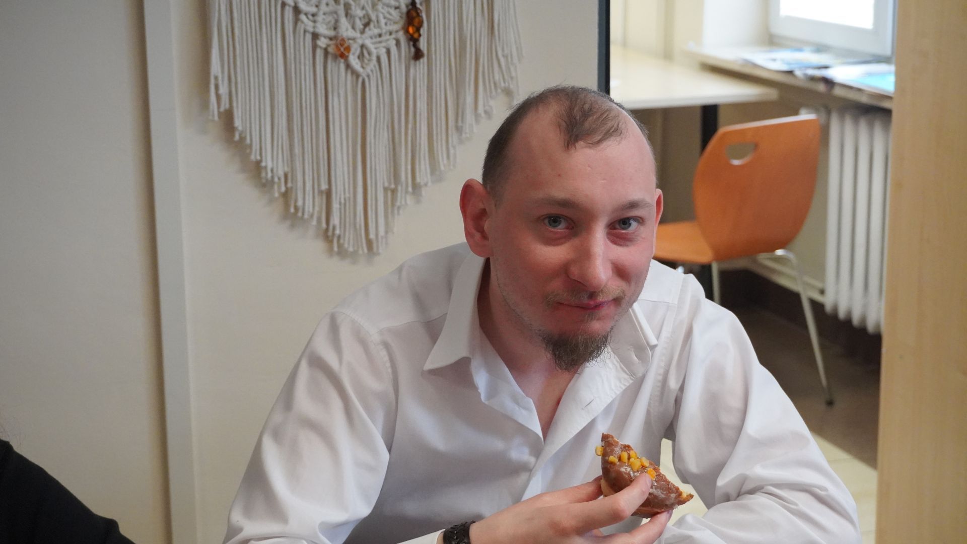 Uczestnik Maciek je pączka.