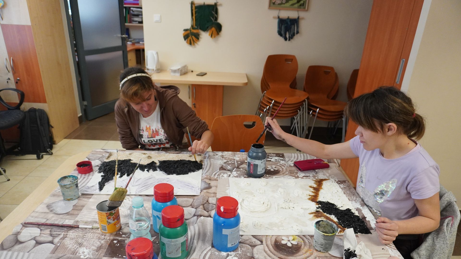 Agnieszka i Małgosia malują farbami prace swoje dzieła, wykonane wcześniej za pomocą specjalnego utwardzacza powertex. 