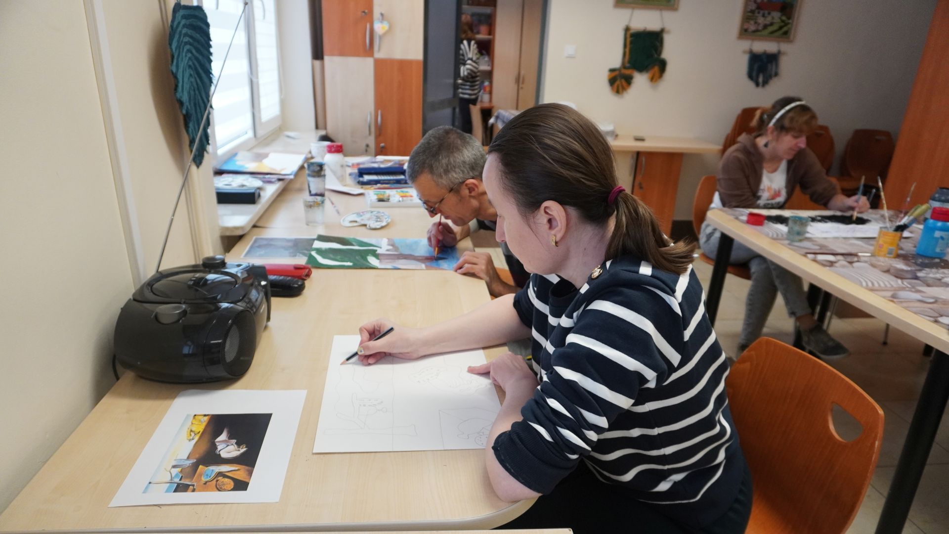 Artystka Ania szkicuje pracę podczas trwania warsztatów plastycznych. 