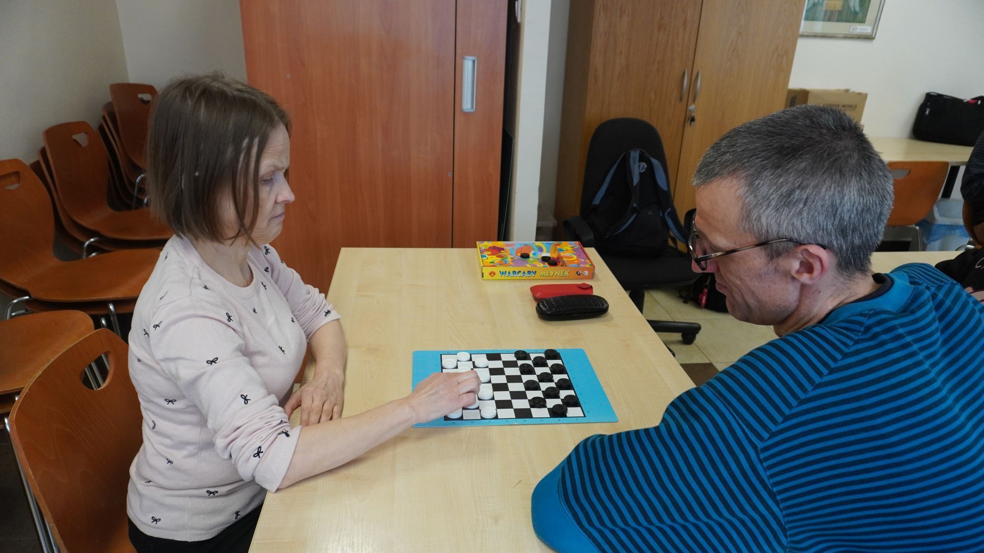 Uczestnicy Monika i Grzegorz grają w warcaby podczas Turnieju warcabowego 2025.