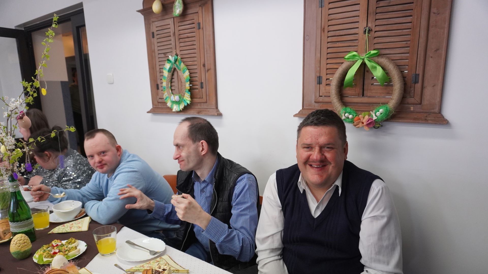 Uczestnicy Darek, Paweł i Damian siedzą przy świątecznym stole podczas spotkania wielkanocnego. 