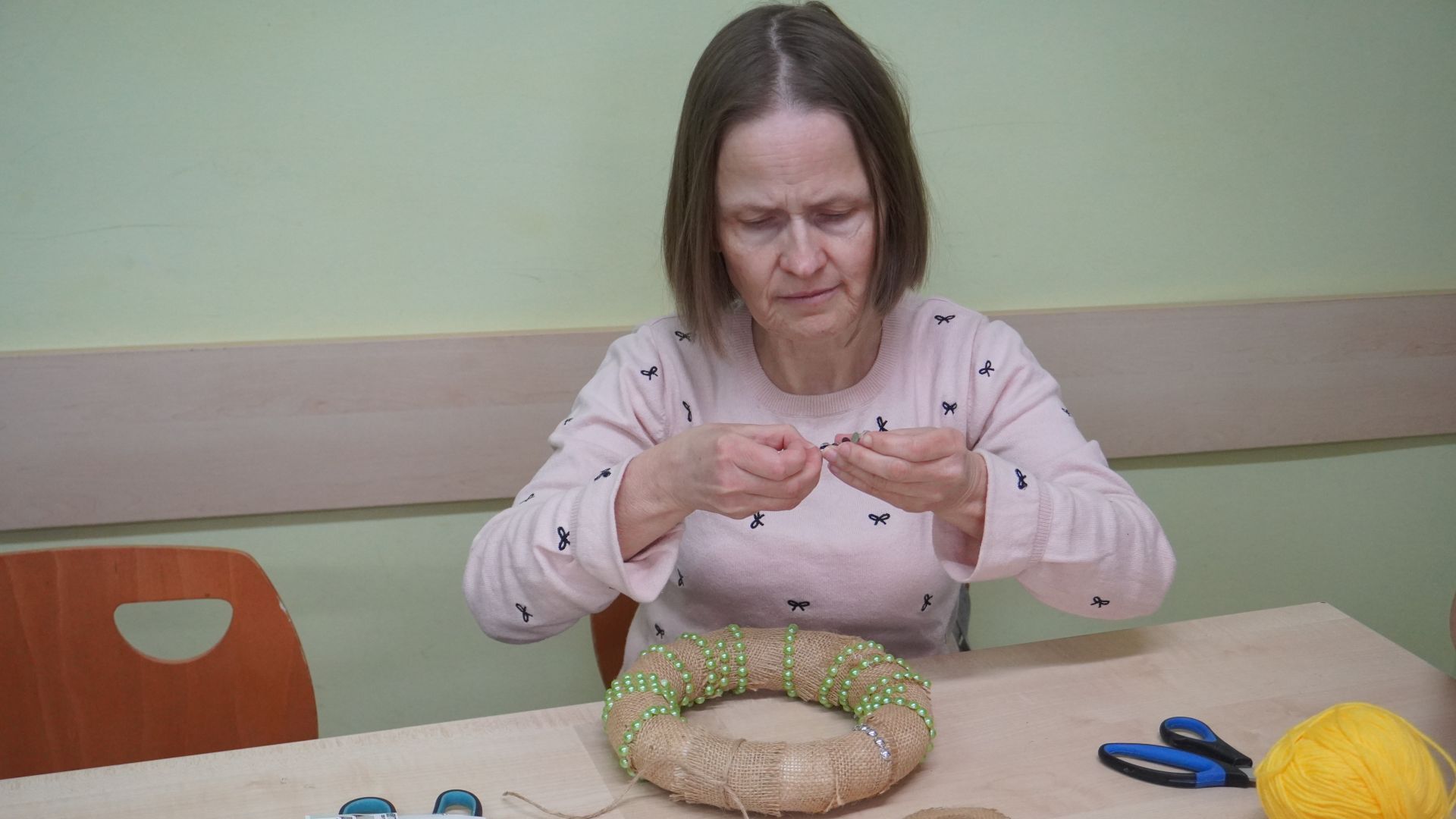 Uczestniczka Monika robi wianek wielkanocny podczas warsztatów wielkanocnych 2025.