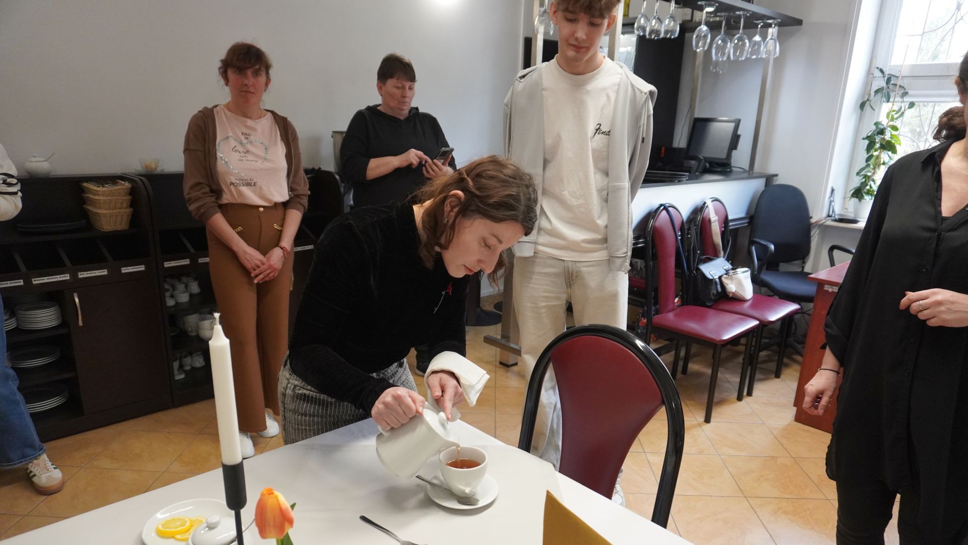 Uczestniczka Justyna K. herbatę do filiżanki podczas warsztatów kelnerskich prowadzonych w ramach KAMPANII SPOŁECZNEJ ''NASZ WSPÓLNY ŚWIAT''.